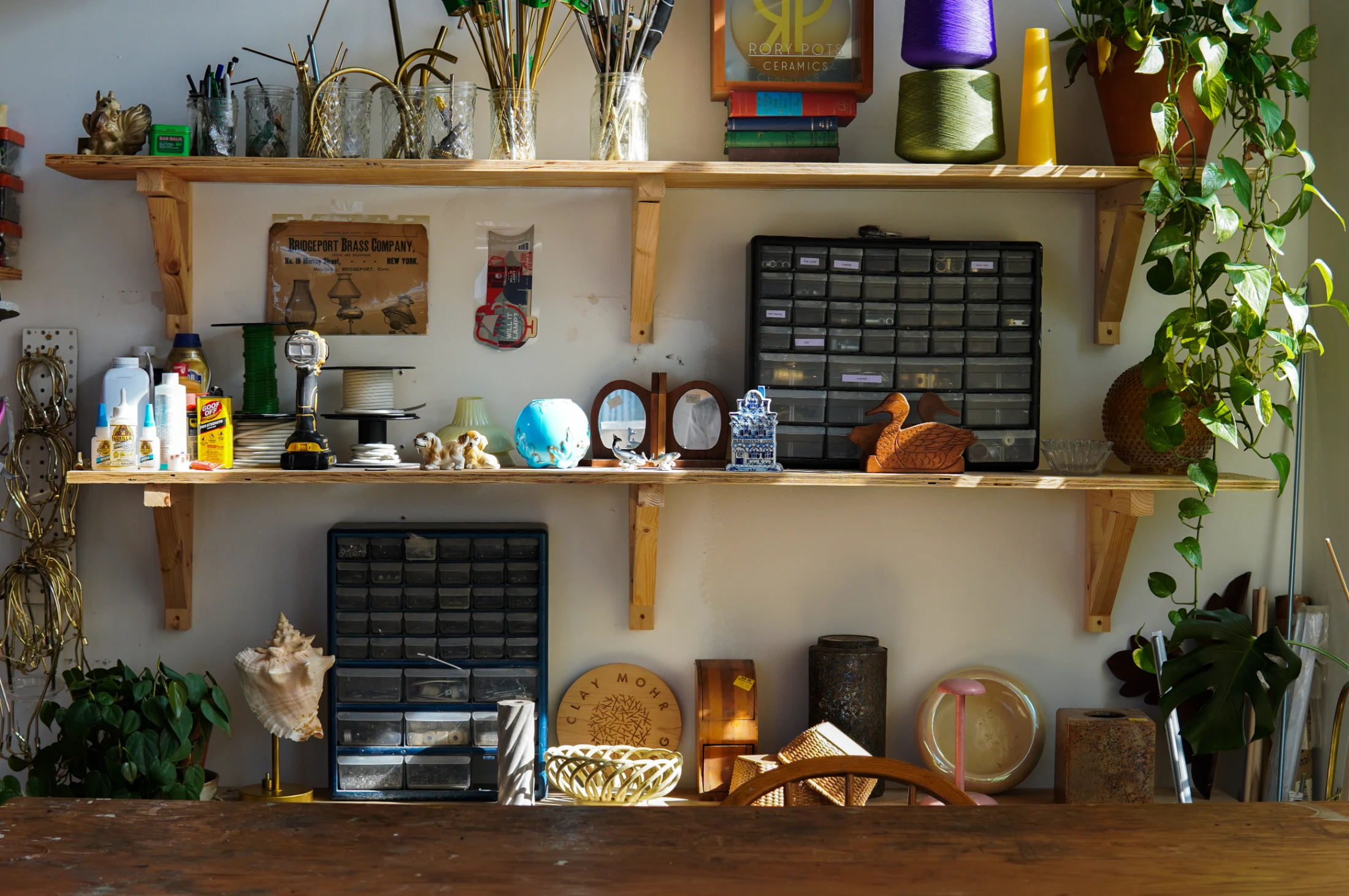 An array of thrifted materials and objects fill the workshop as potential 'lamping' projects.