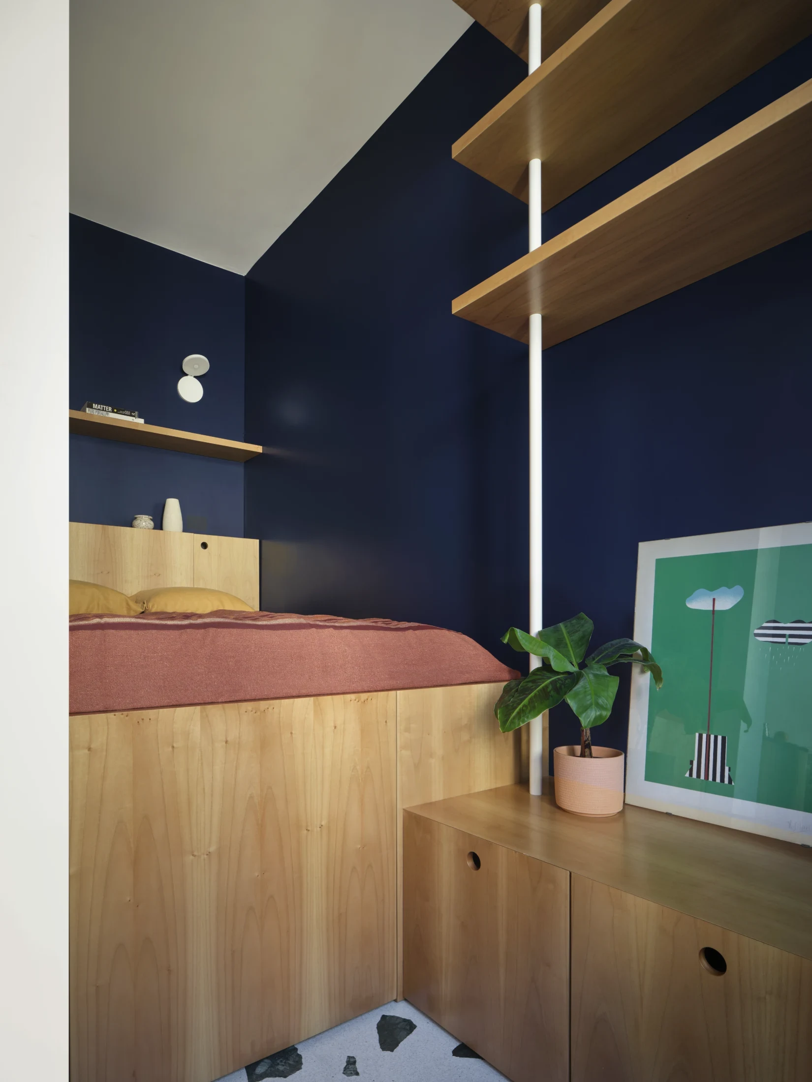 The elevated bed features generous storage beneath as well as a retractable step concealed within the cabinet 'drawer' that meets its base.