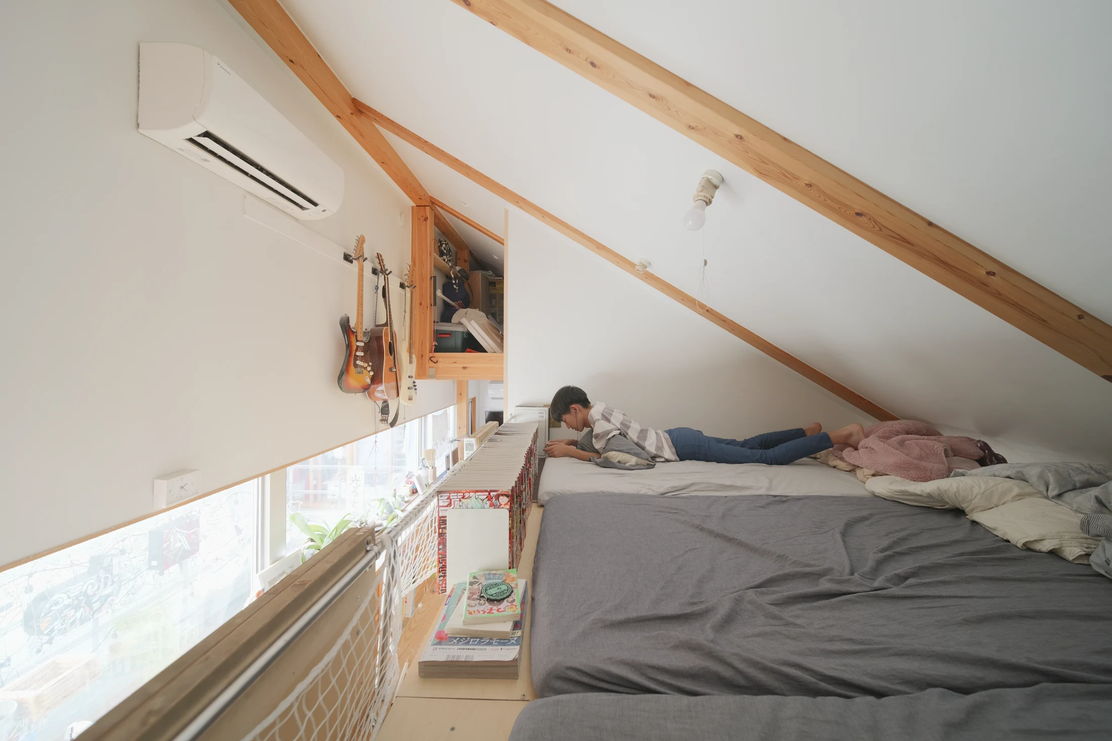 The children's bedroom is a loft space above their large shared desk and accessed via protruding shelves in an adjacent bookshelf that serve as a ladder. When the children are older this space will be reconfigured into three individual bedrooms.
