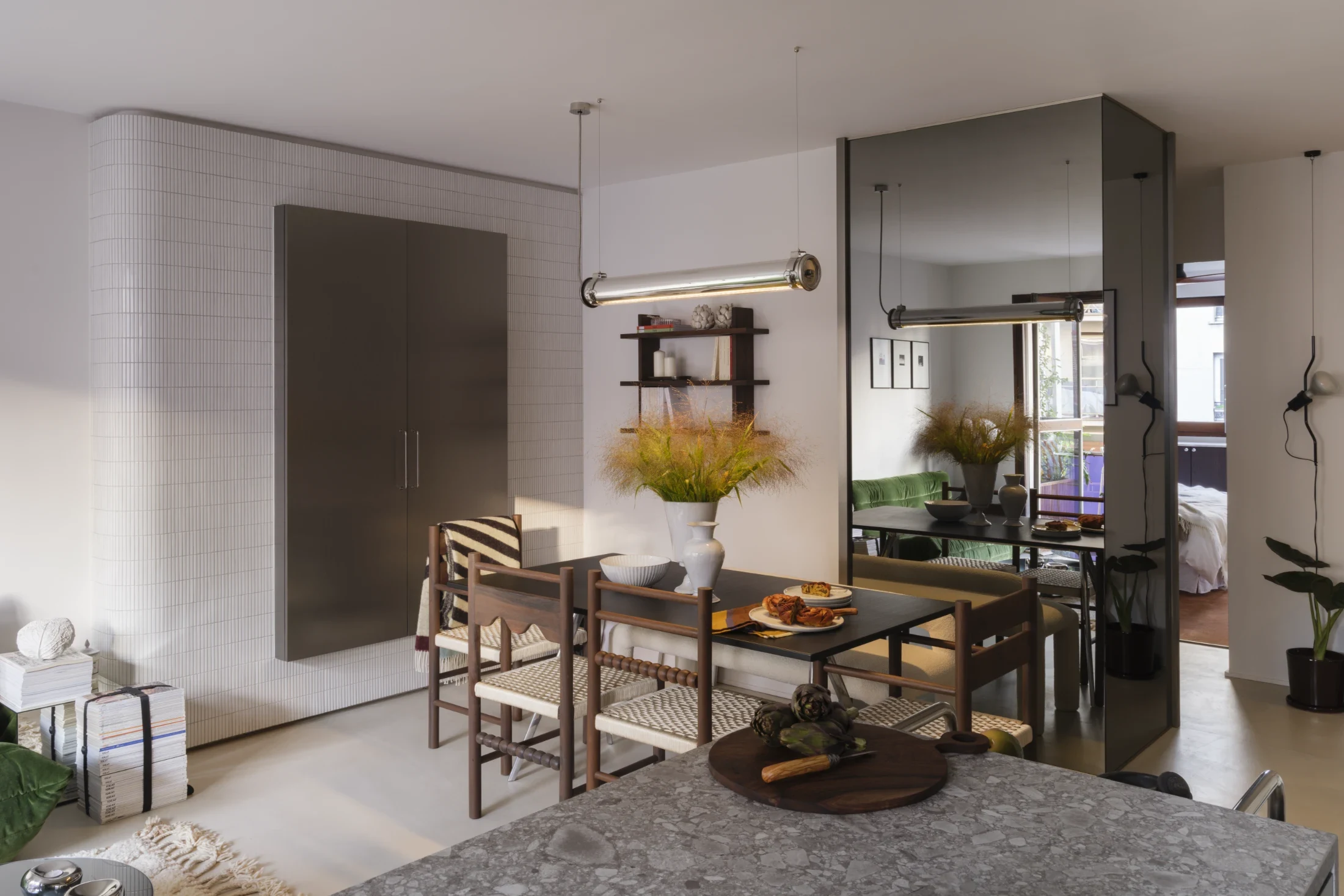 The side panel and back of a storage closet is clad in floor to ceiling mirrors – a device that expands the sense of space in the room while also reflecting light.