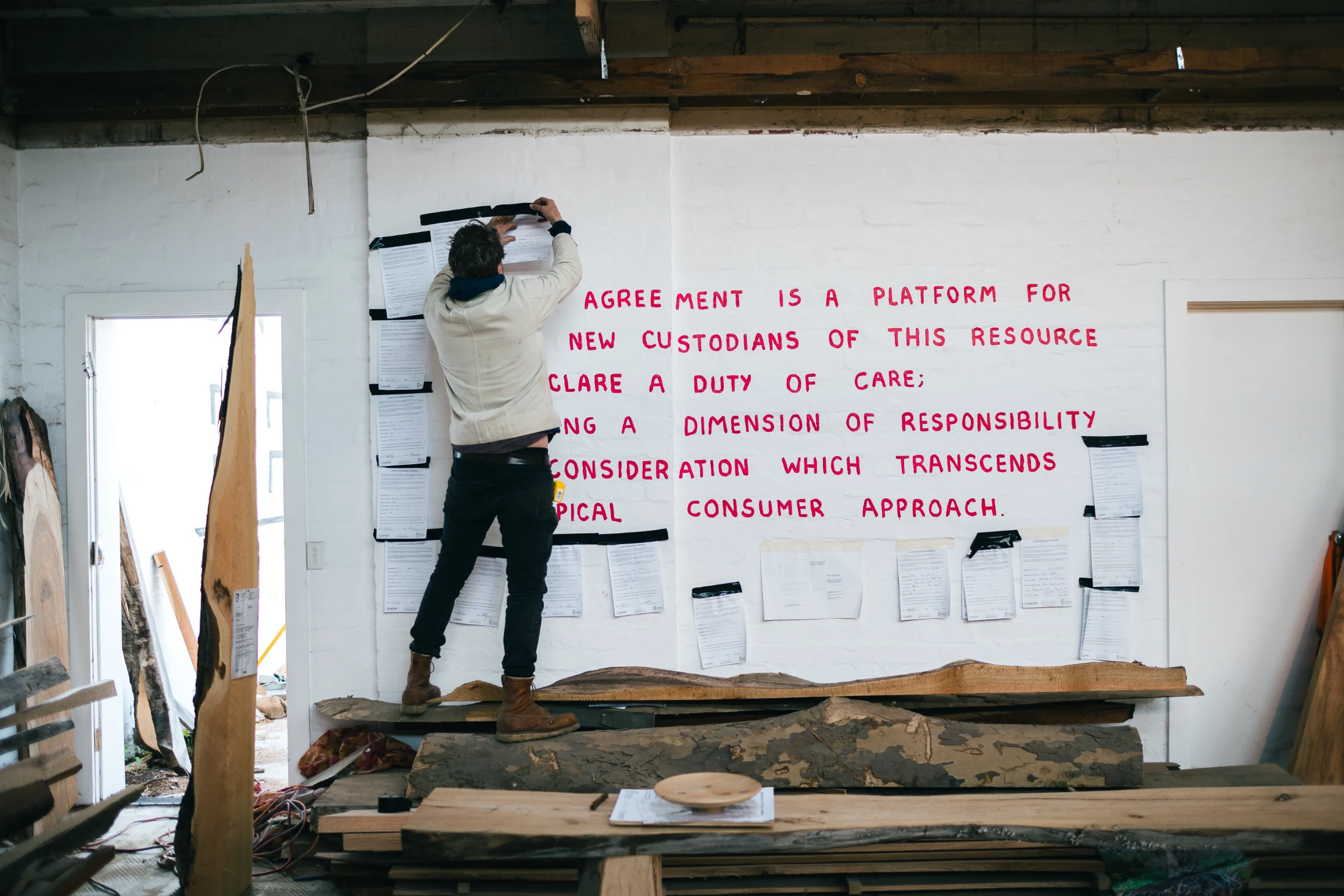 Robbie tapes up a custodian agreement to the wall as part of Revival's Urban Tree Recovery Initiative.