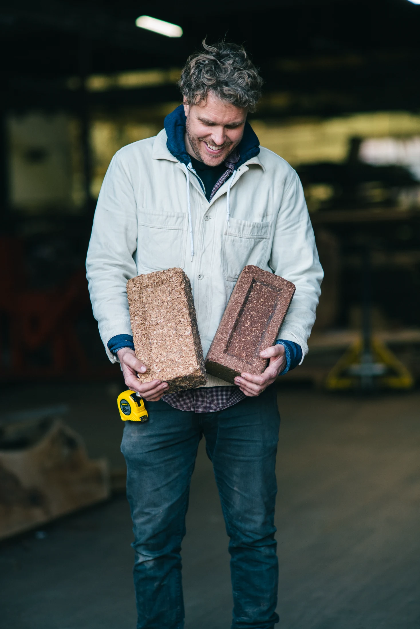 Robbie holds one of his latest innovations: sawdust-based bricks. The bricks have been stress tested and are as strong as traditional masonry bricks.