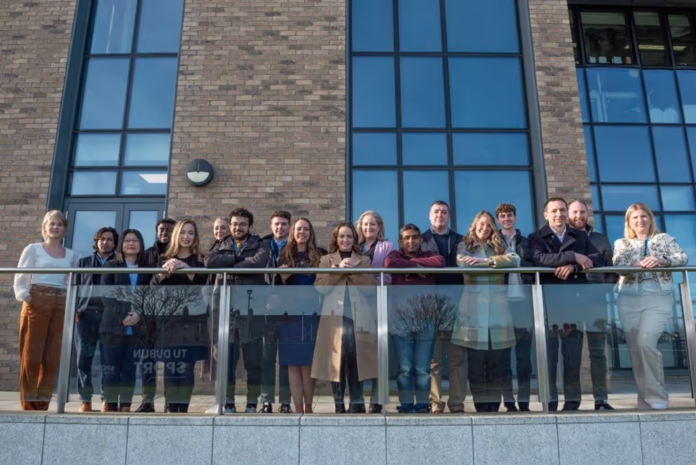 Large group of people standing on a balcony smiling