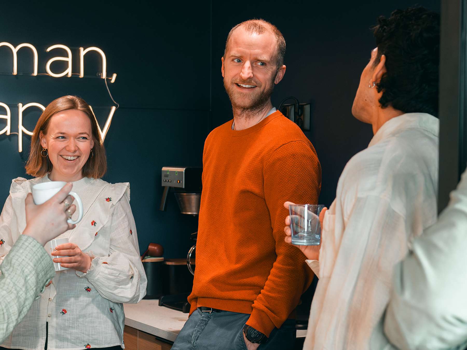 Tre konsulenter som prater og drikker kaffe. Foto