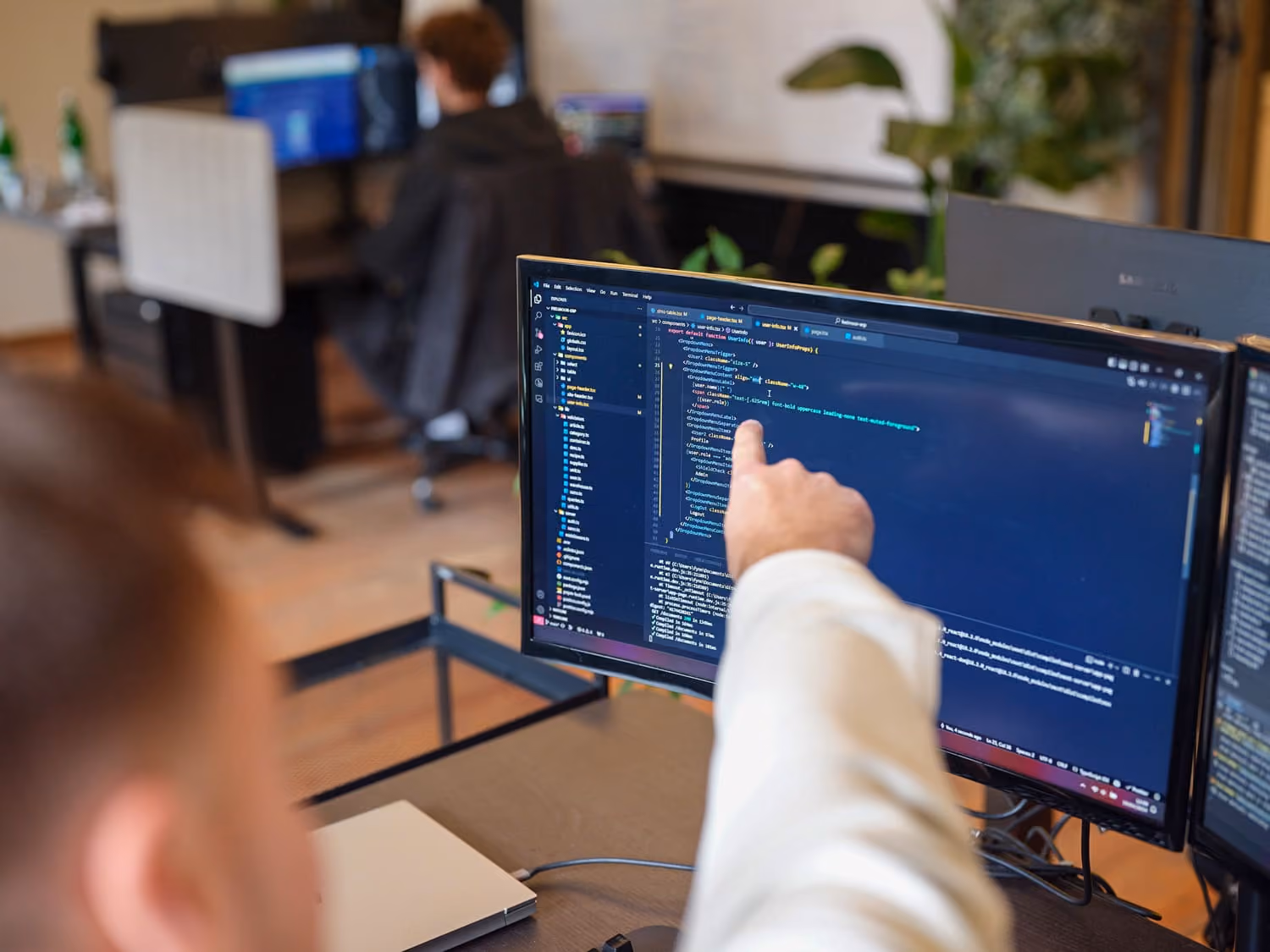 Ein Mitarbeiter von we-site erklärt einem anderen Mitarbeiter Code.