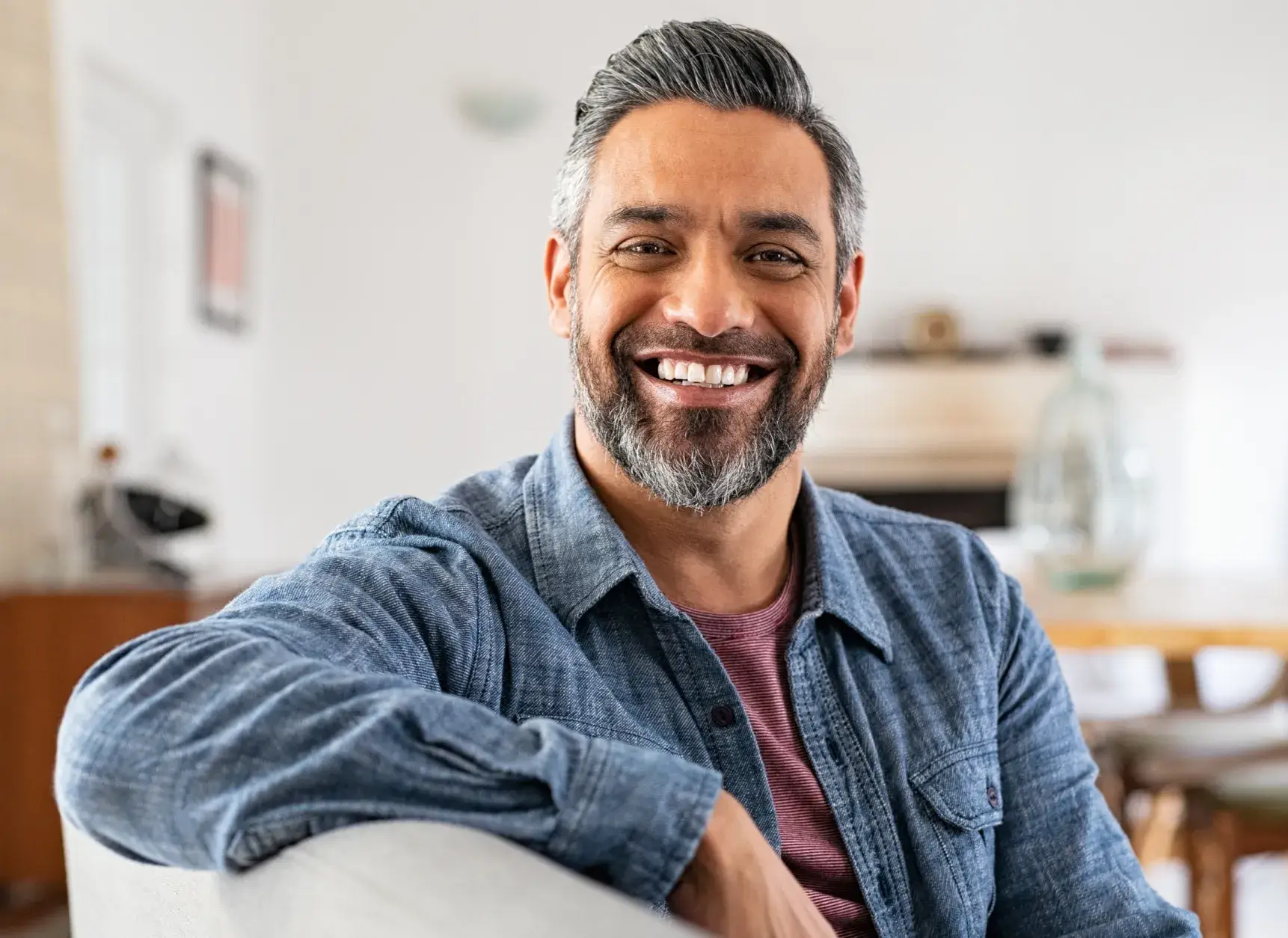 A man sitting in a chair smiling at the camera.