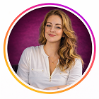 Smiling woman with long wavy hair wearing a white button-up shirt against a purple background.