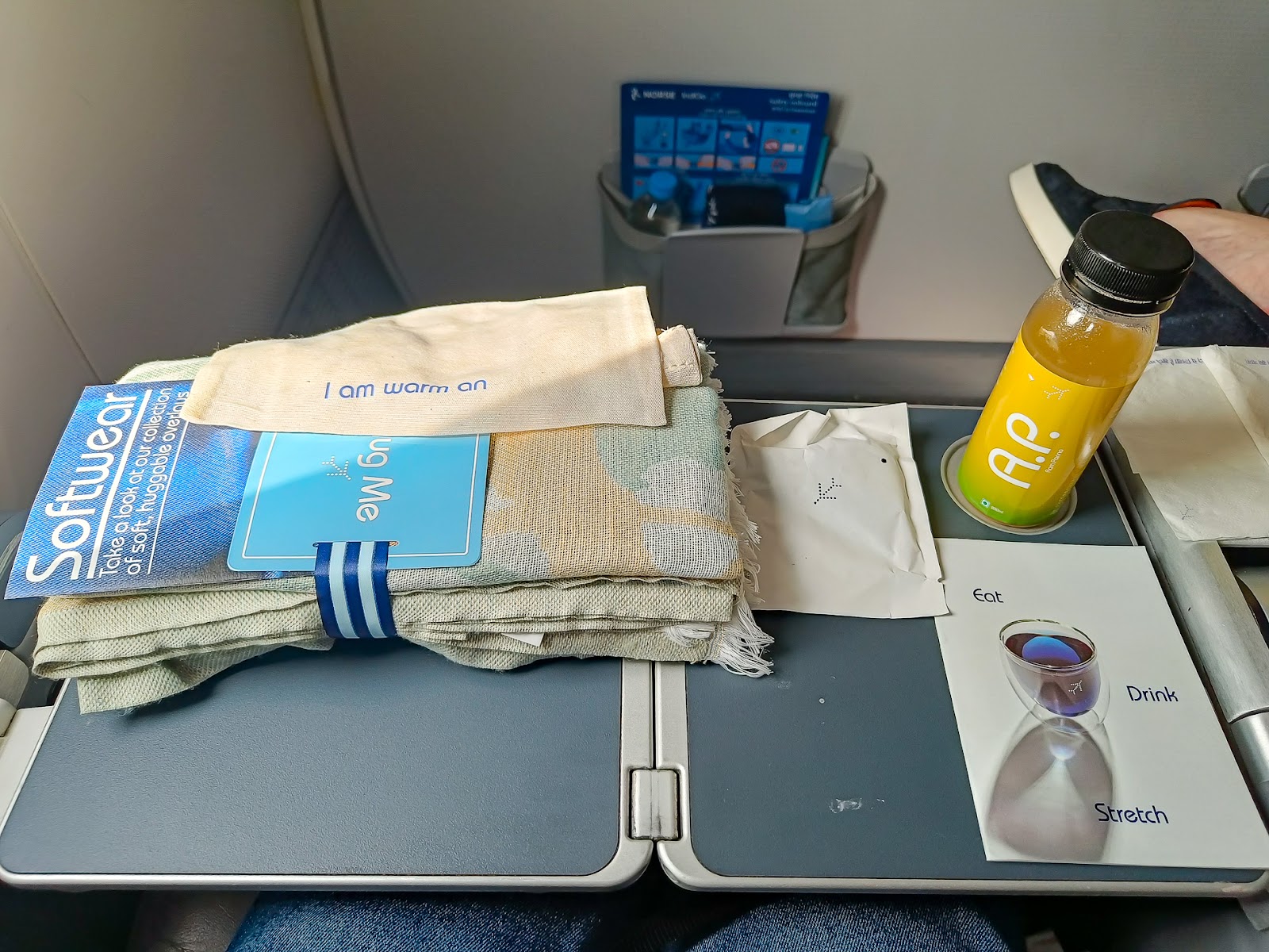 Cabin Crew welcomed the passengers with amenities such as blankets and ear phones, also including socks and ear phones, not included in the picture.