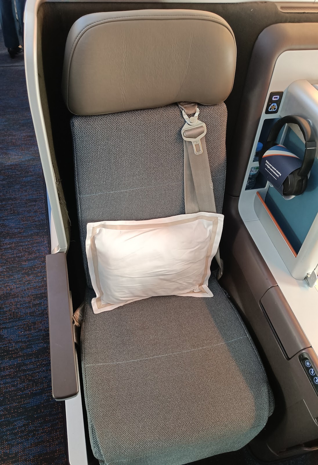 Business Class seat at 1C with a noise cancelling headphone and water of bottle. Photo: Shyam VimalKumar/ Airways