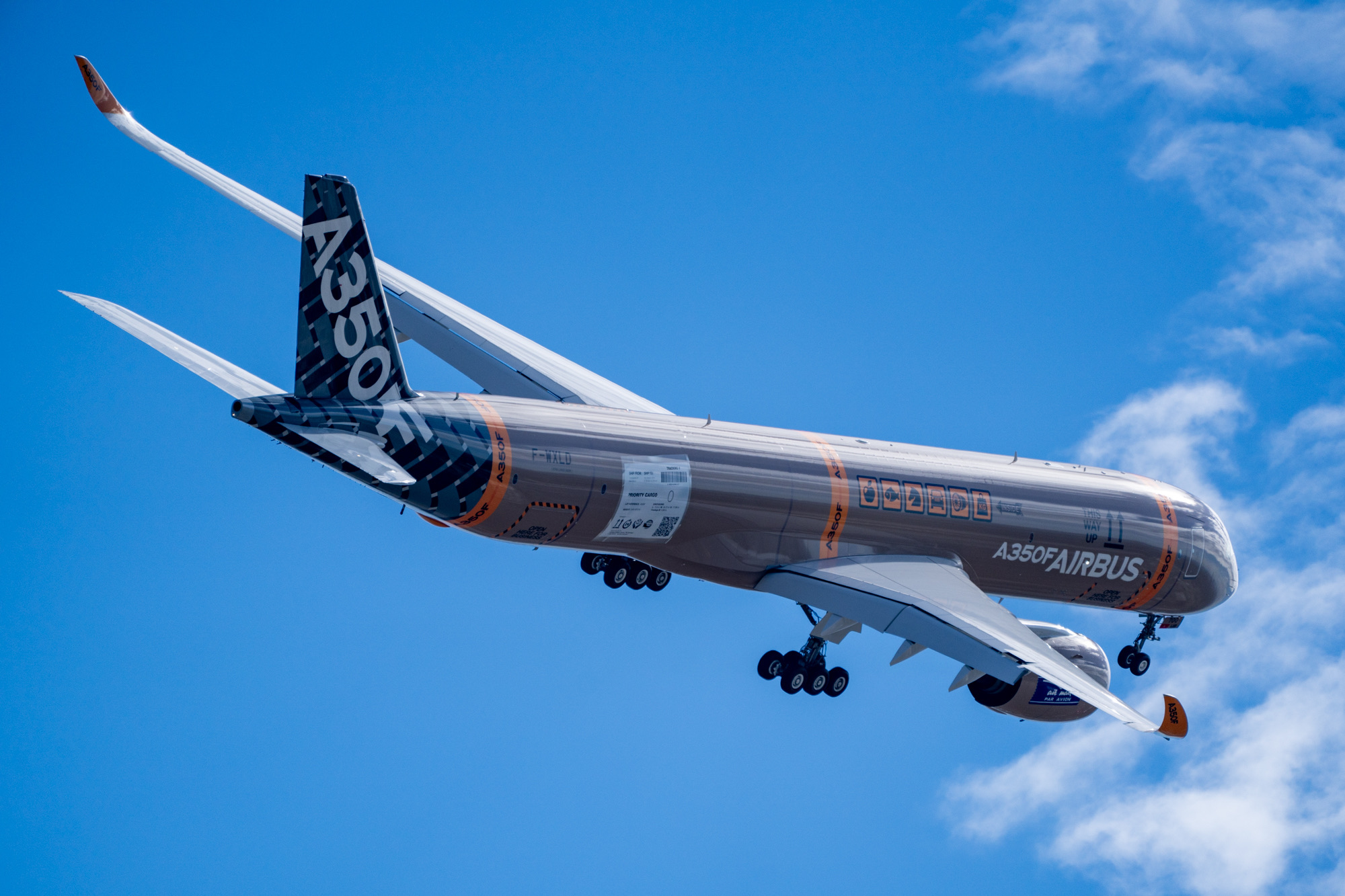 A350F in flight from the side, showing the upper fuselage and wing, with landing gear extended.