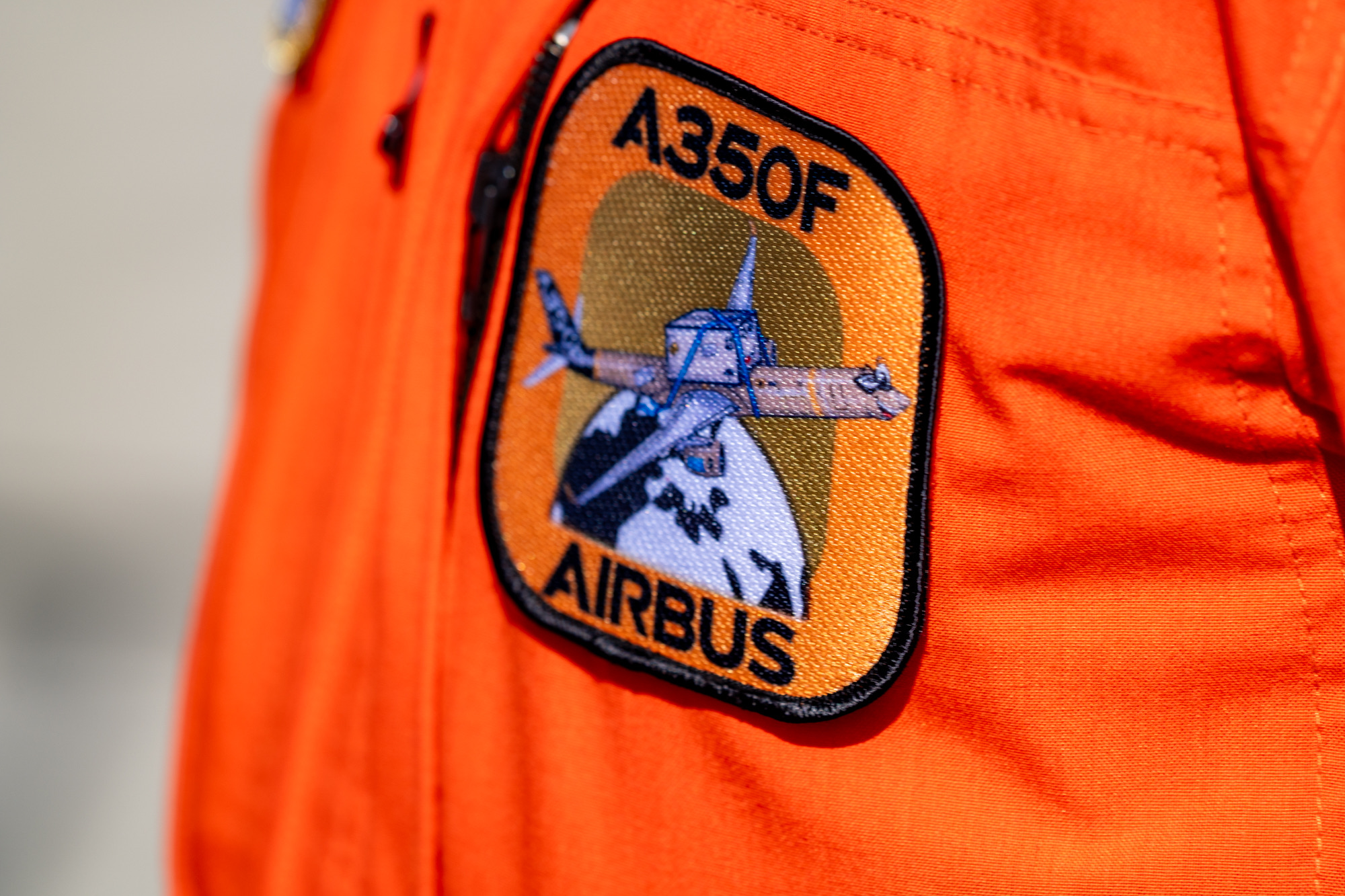 Close-up of an embroidered A350F Airbus patch on an orange flight suit.