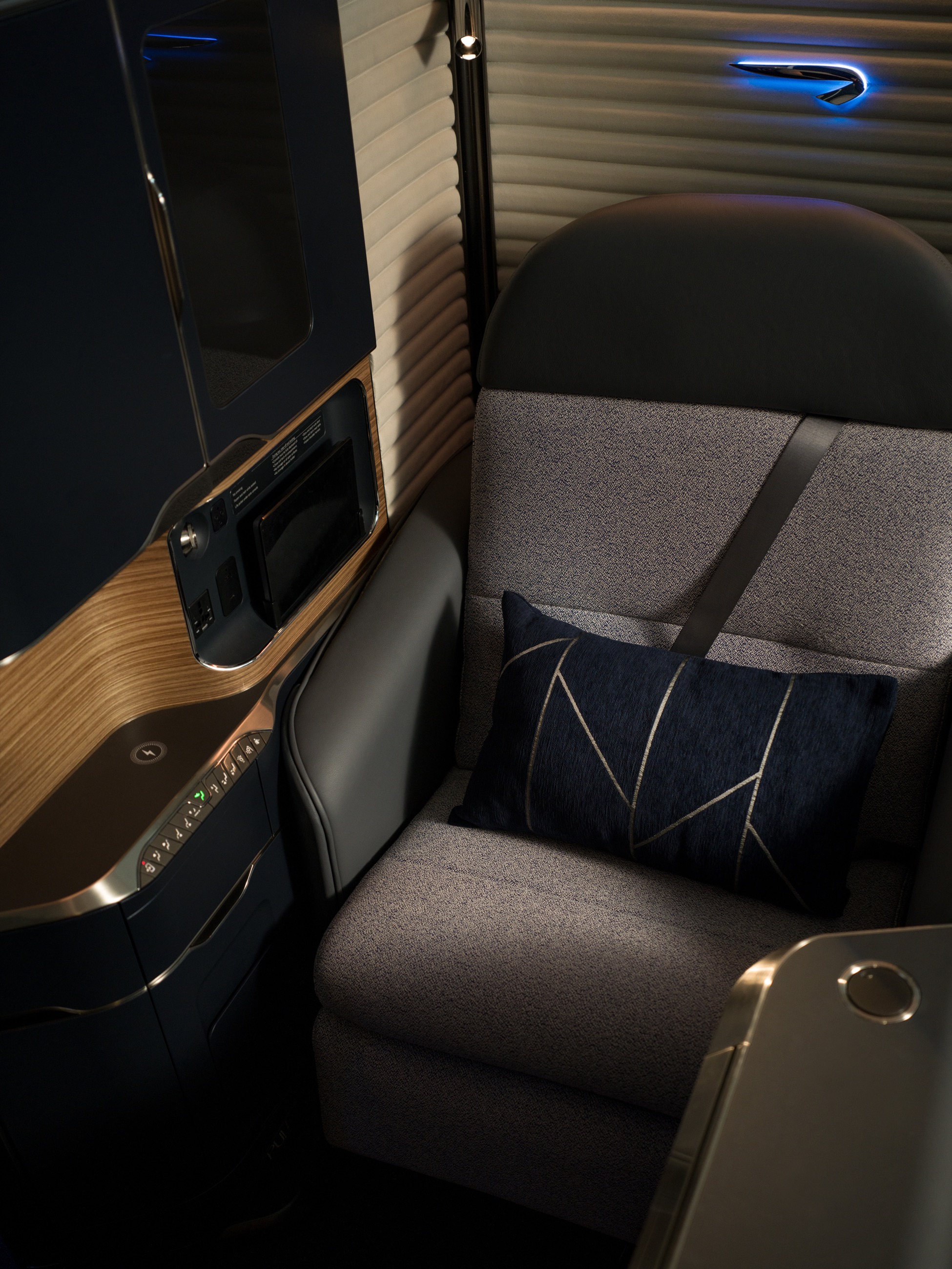 British Airways' First suite seat with a navy cushion, side controls and illuminated Speedmarque.