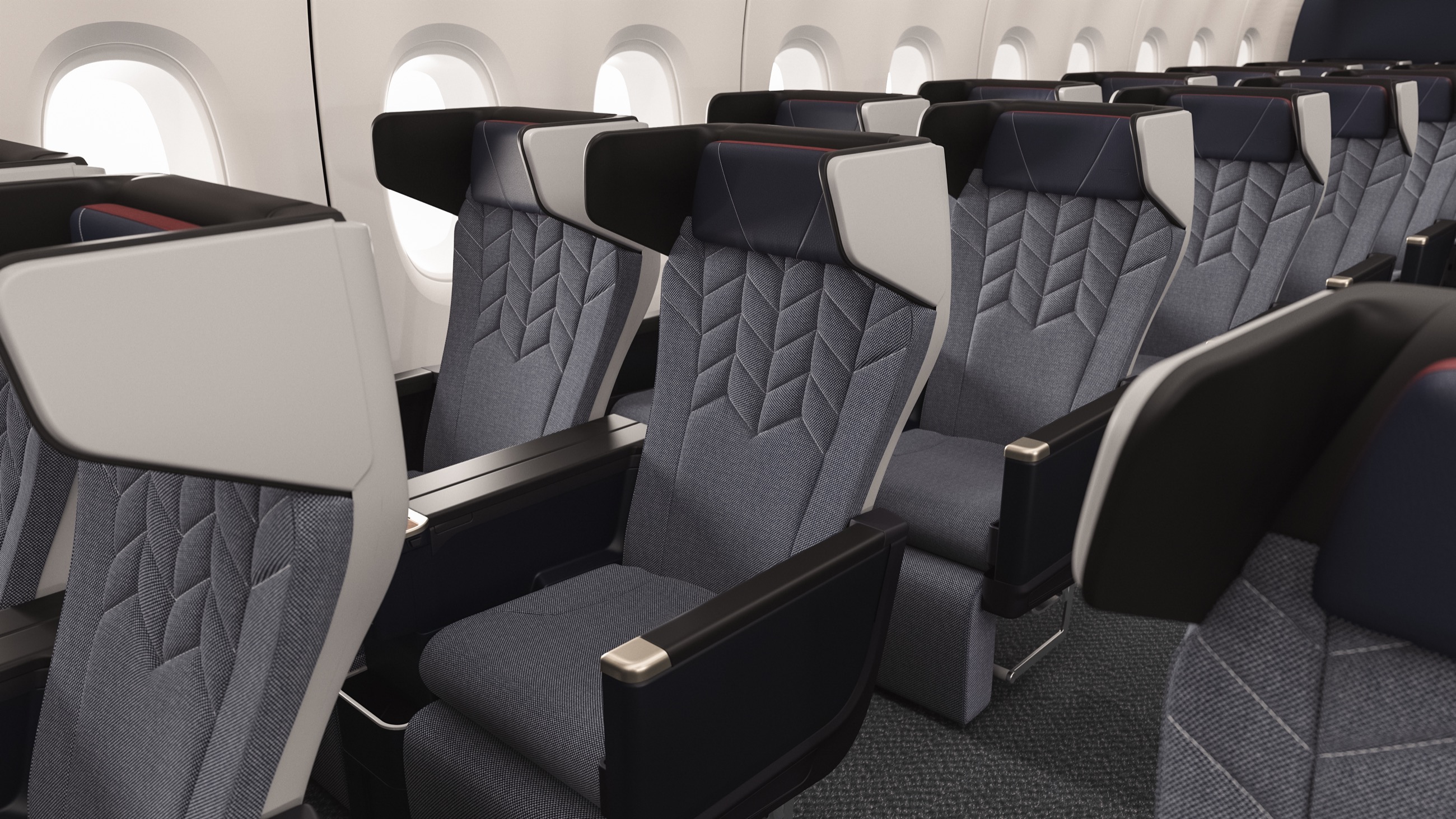 World Traveller Plus seats with patterned upholstery and extended privacy wings around the headrests.