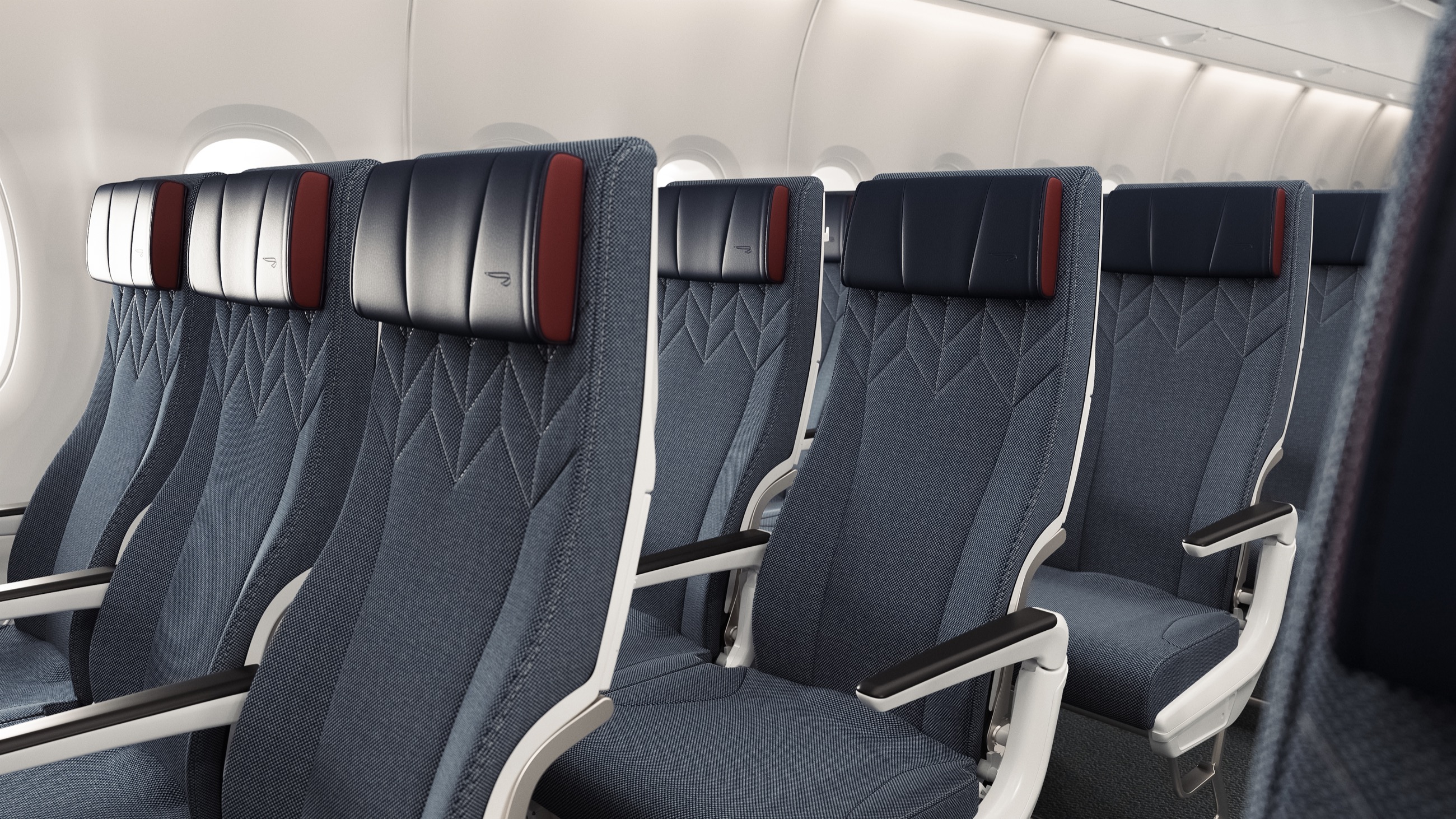 World Traveller seats with blue headrests, red accents and patterned fabric upholstery.
