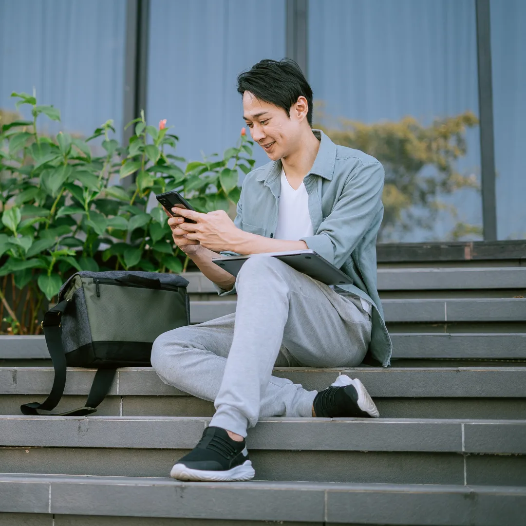 Man sitting on stairs checking phone