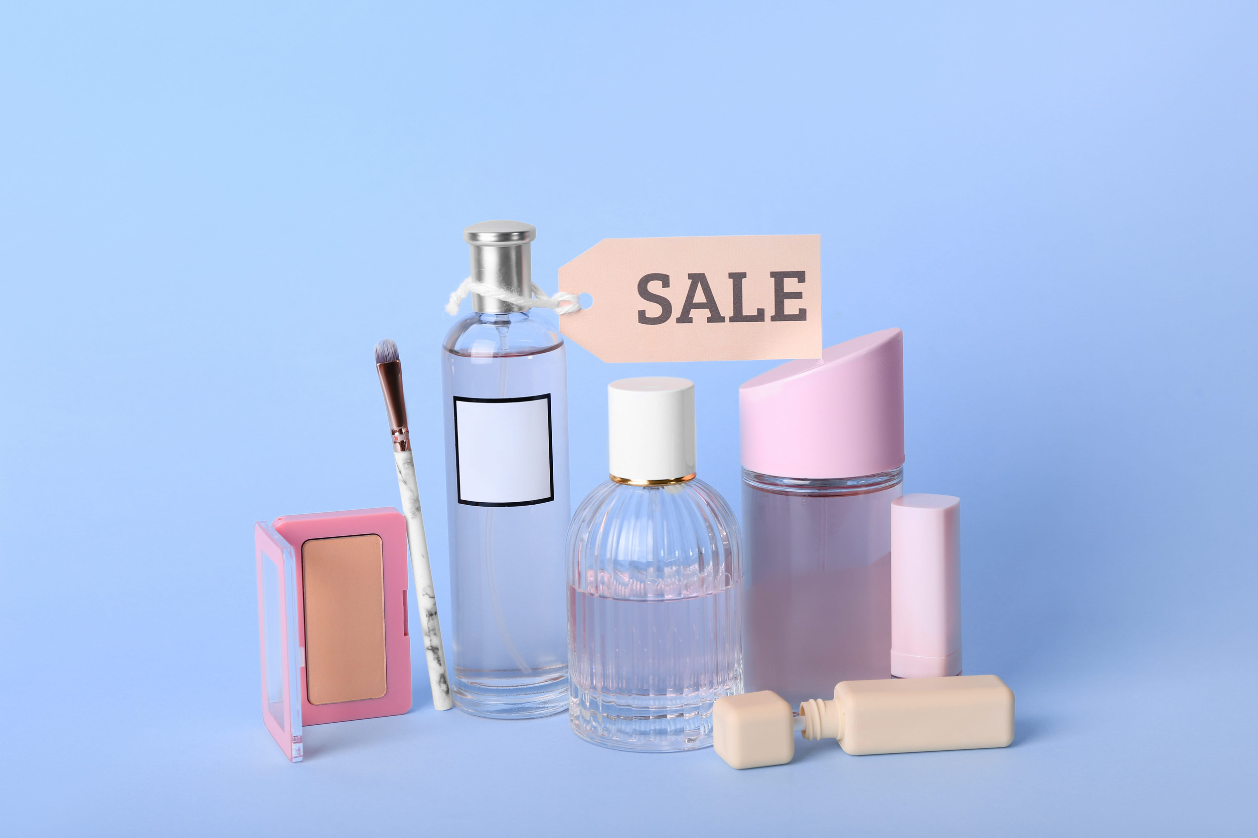 Perfume bottles and gift boxes with a Sale sign.