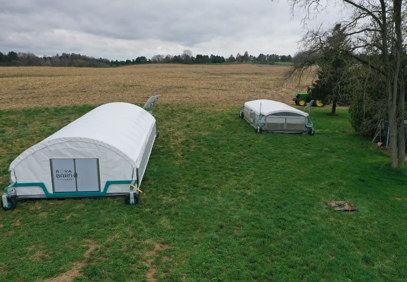 Two ROVA|BARN units placed side-by-side in a field near the De Boers’ home, captured on a cloudy day.
