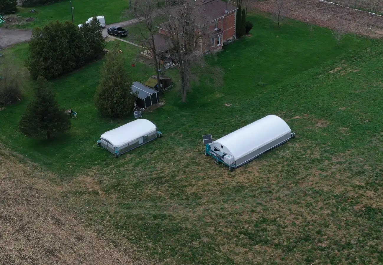 Aerial view of the De Boer family farm with two ROVA|BARN units positioned in the grassy area near their home.