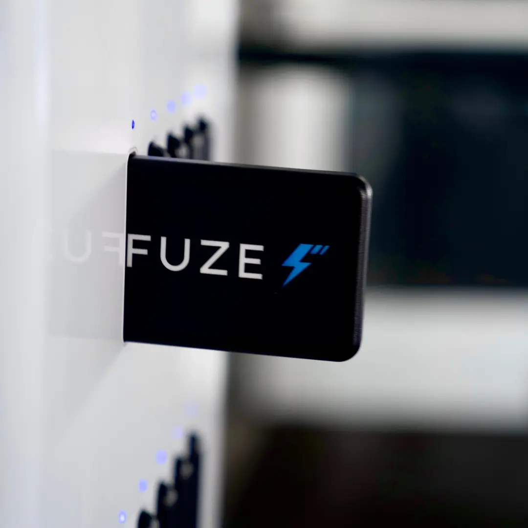 Stadium phone charging stations showing close-up of FUZE branded portable charger being ejected.