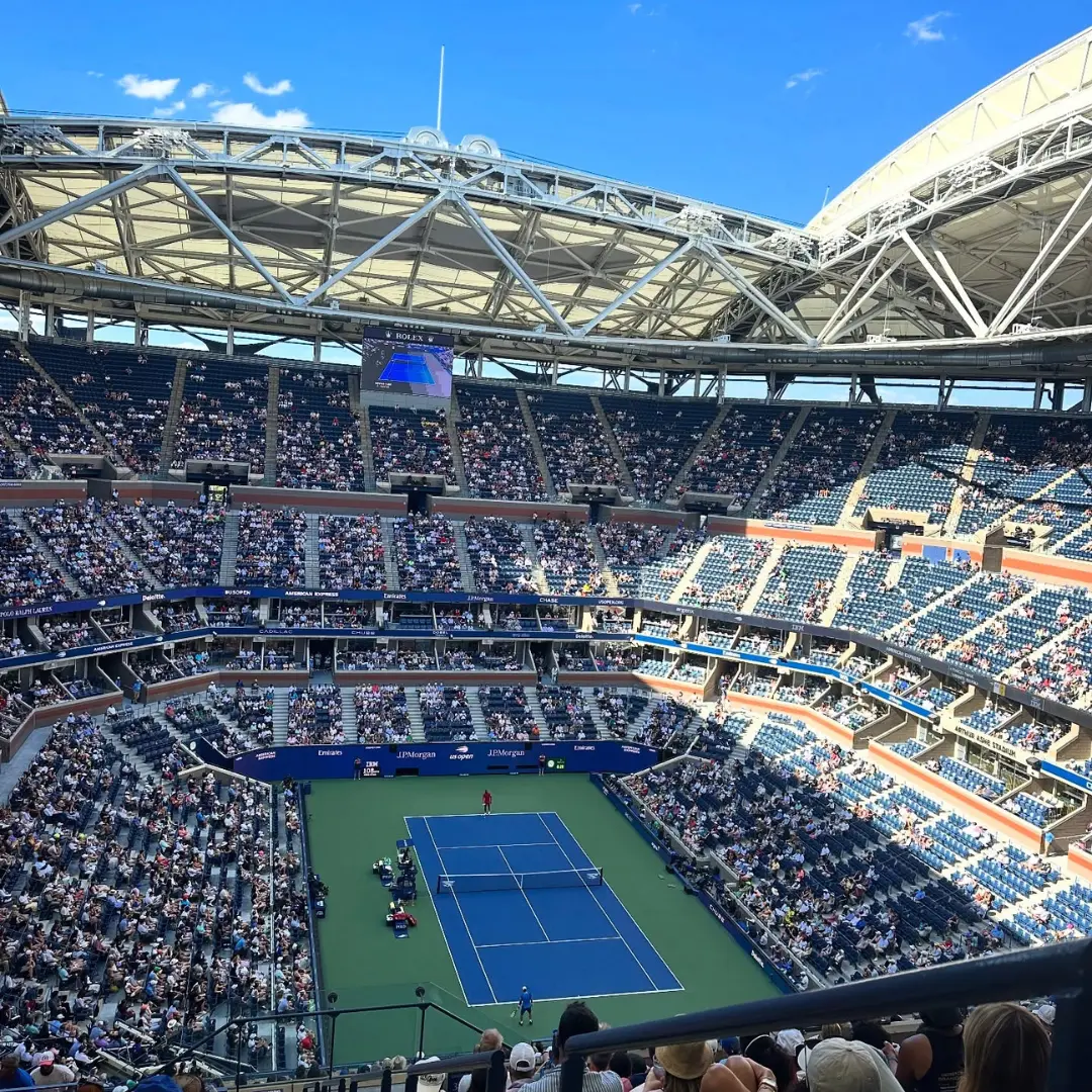 Phone charging stations for events available at packed tennis stadium during a live match.
