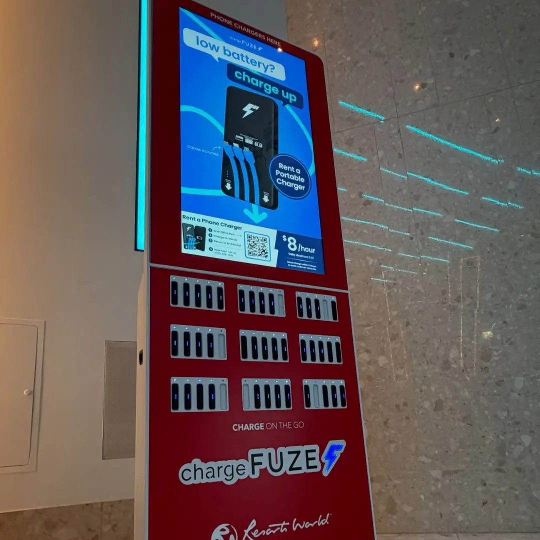 Phone charging stations for events as a red ChargeFUZE kiosk offers portable charger rentals for $8 per hour at Resorts World