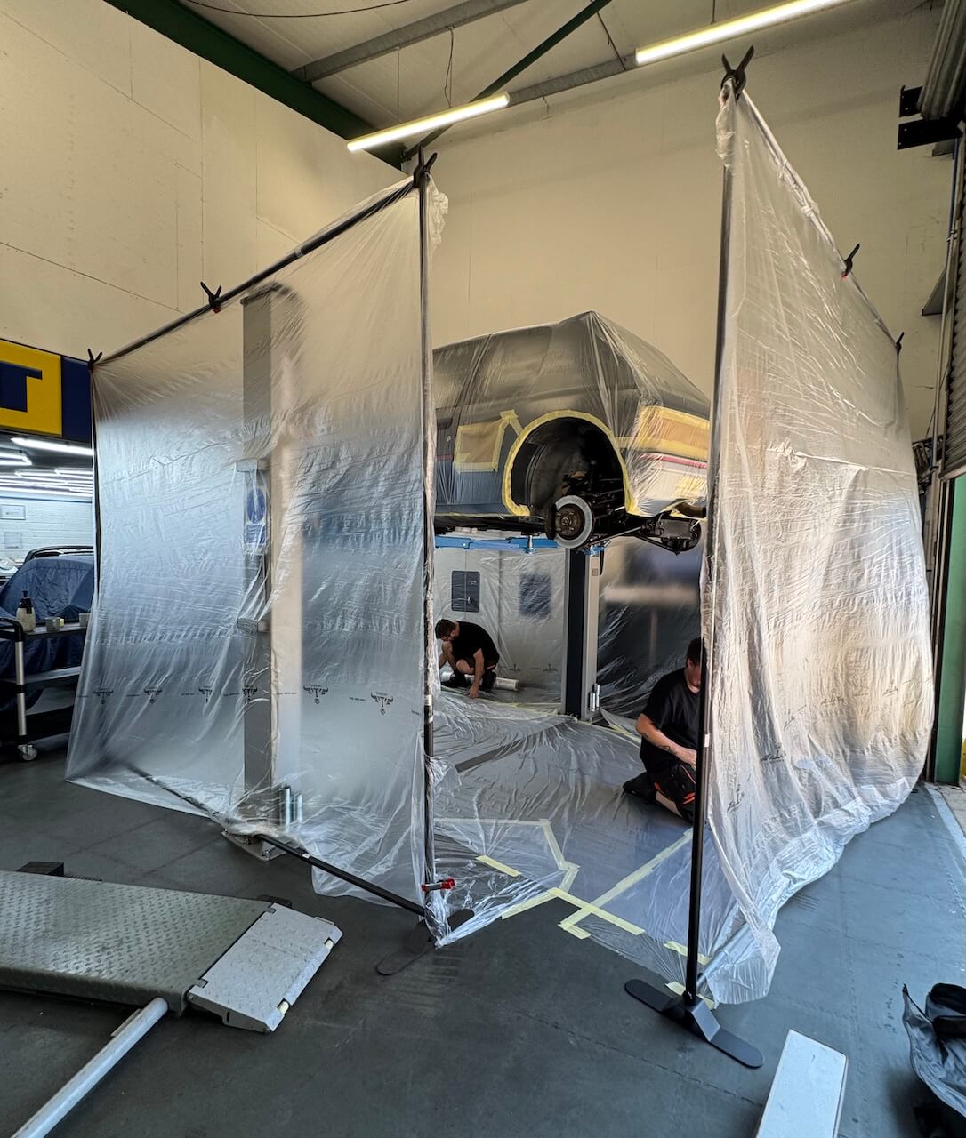 Technician performing precision dry ice blasting on a vehicle at IceBlastPro facility.