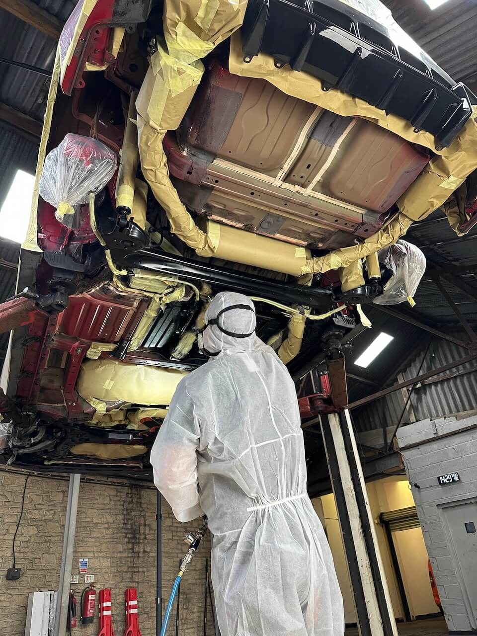 Two technicians smiling infront a vehicle before precision dry ice blasting at IceBlastPro facility.