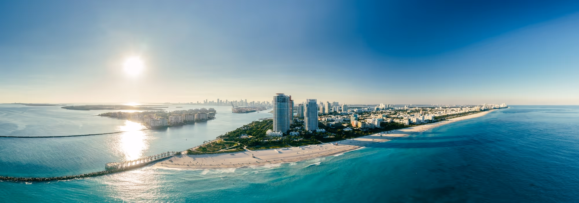 the sky view of the city in florida and the peninsula on a sunny day with clear blue waters 