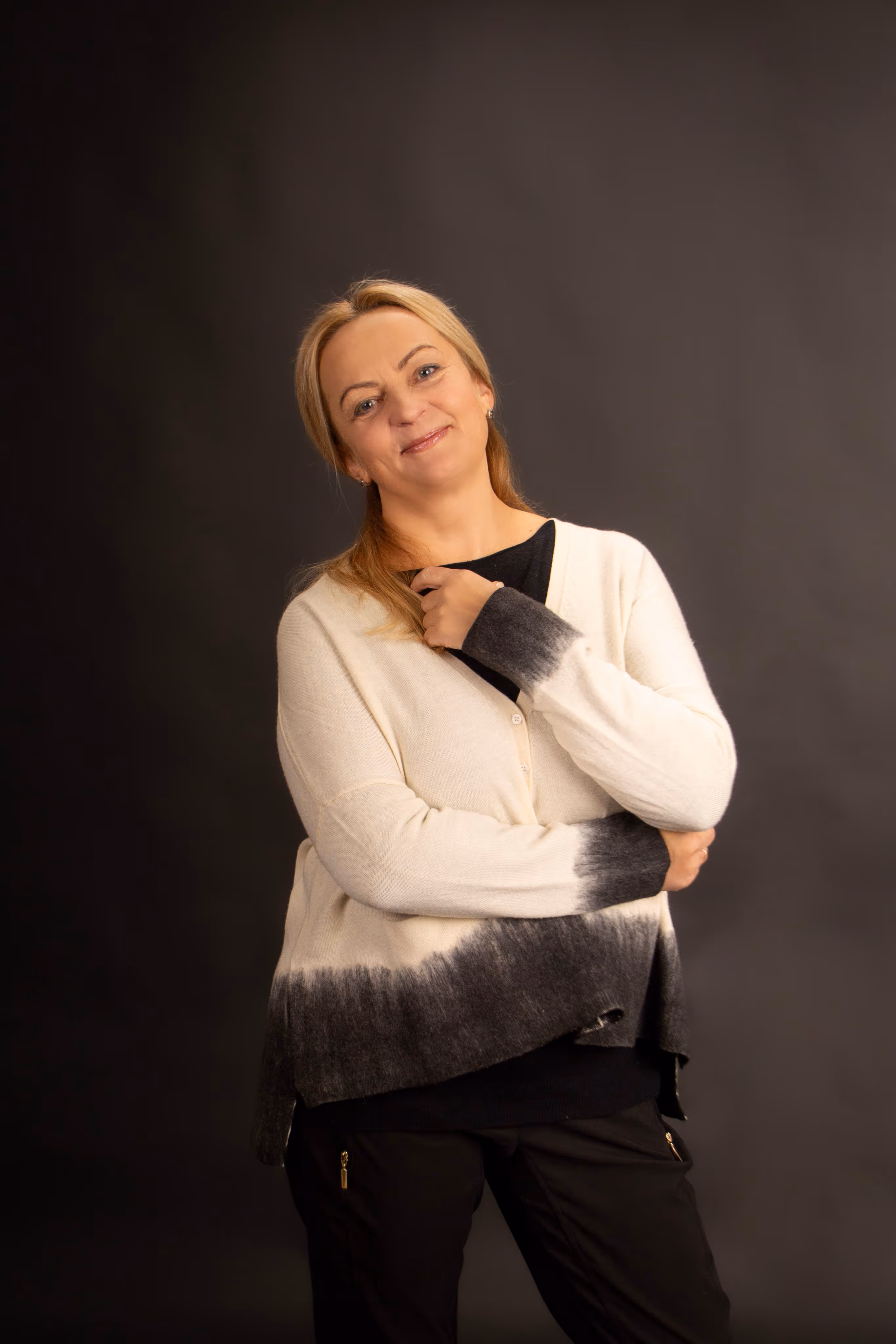 Nice, smiling woman on dark background looking directly at cam
