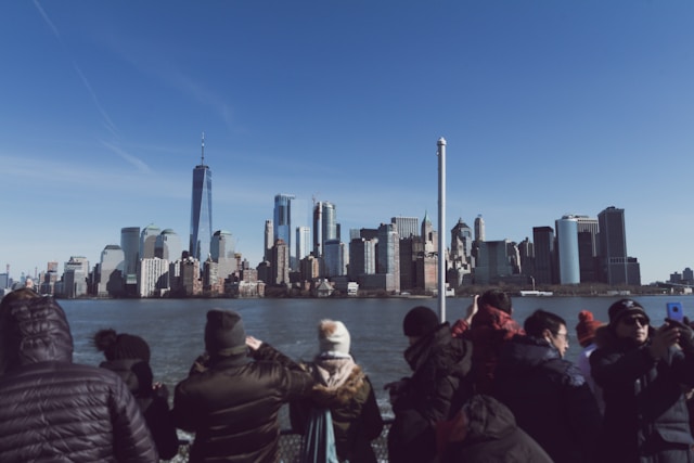 A group of tourists taking photos of the New York City skyline