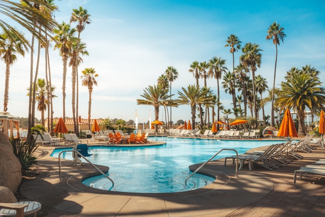 A hotel pool with lounge chairs and palm trees
