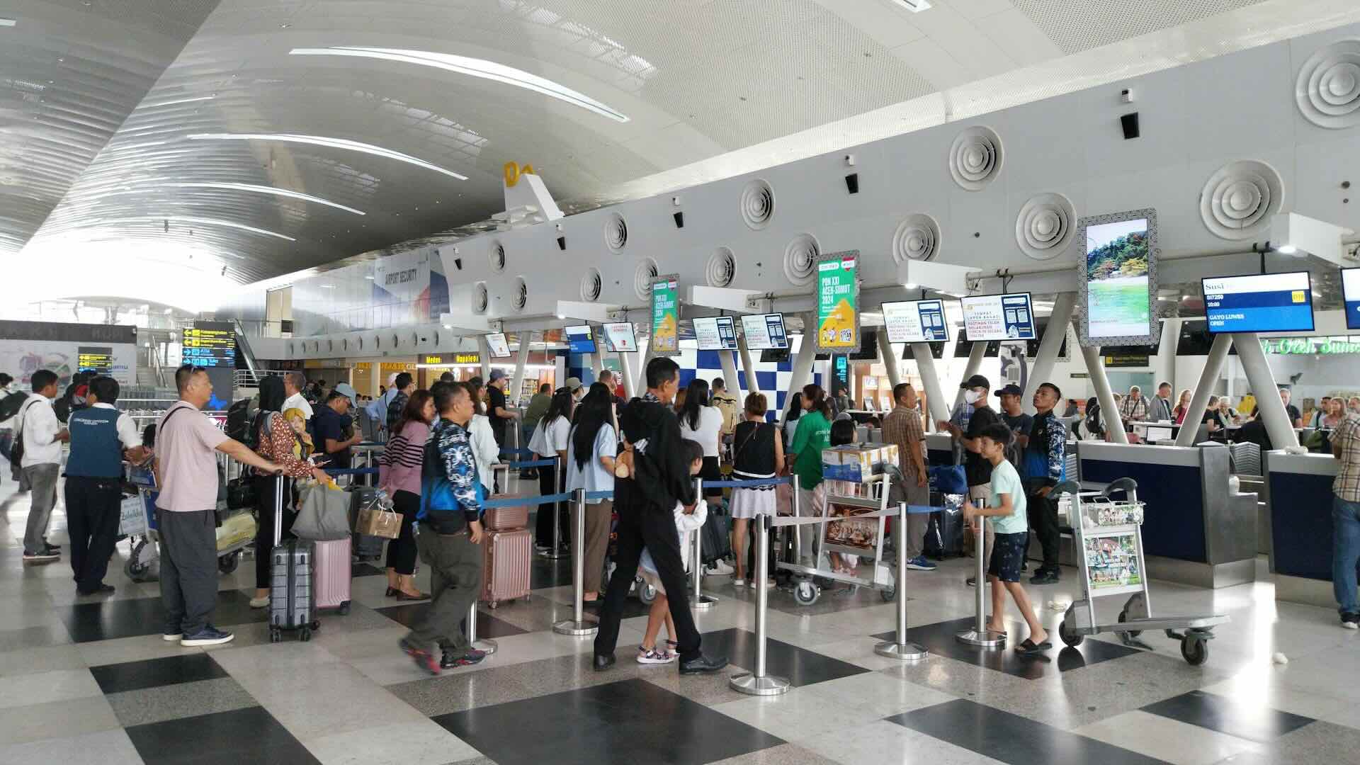 People standing in line at the airport check-in counter