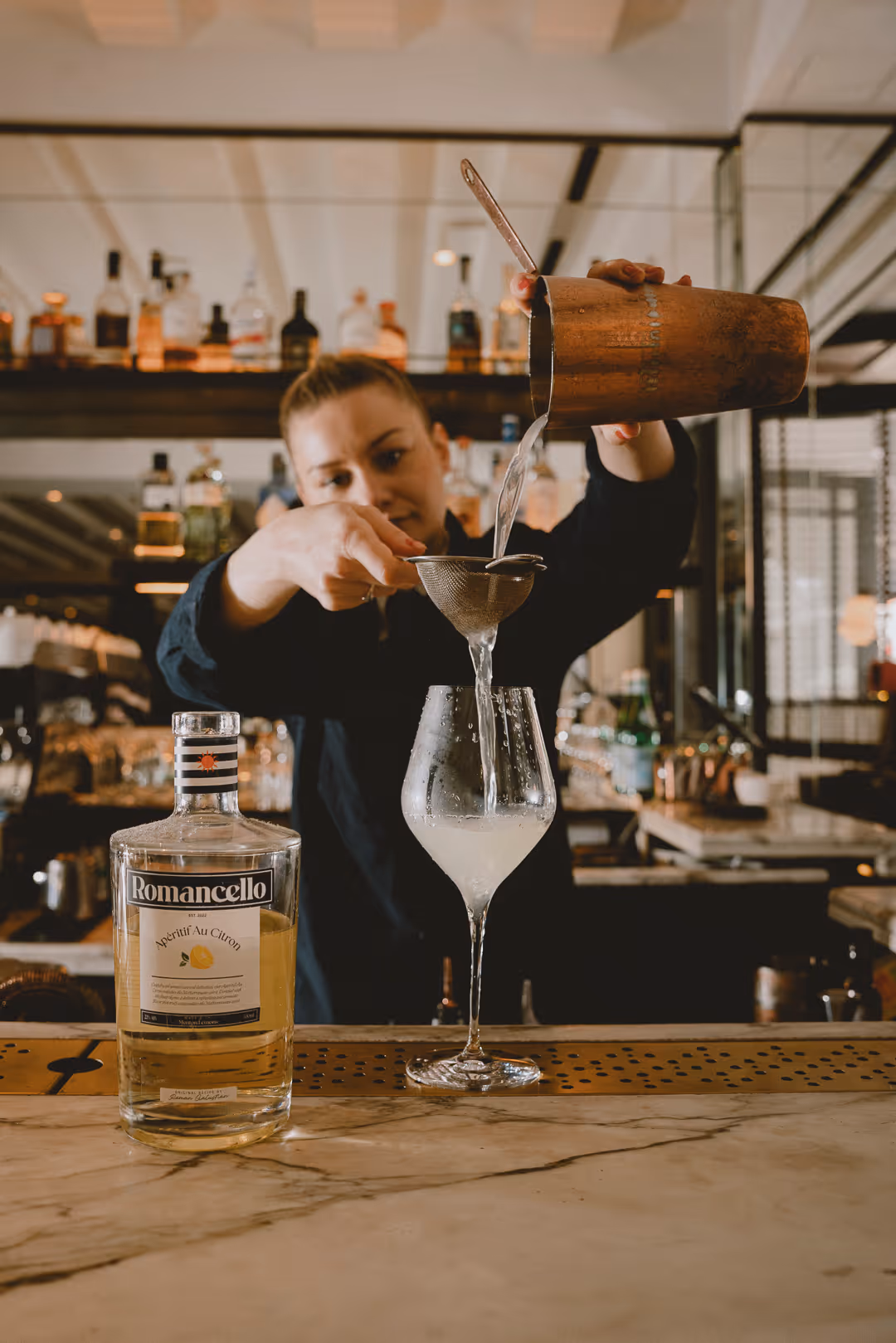 Making a Romancello Spritz — pouring lemon aperitif over ice