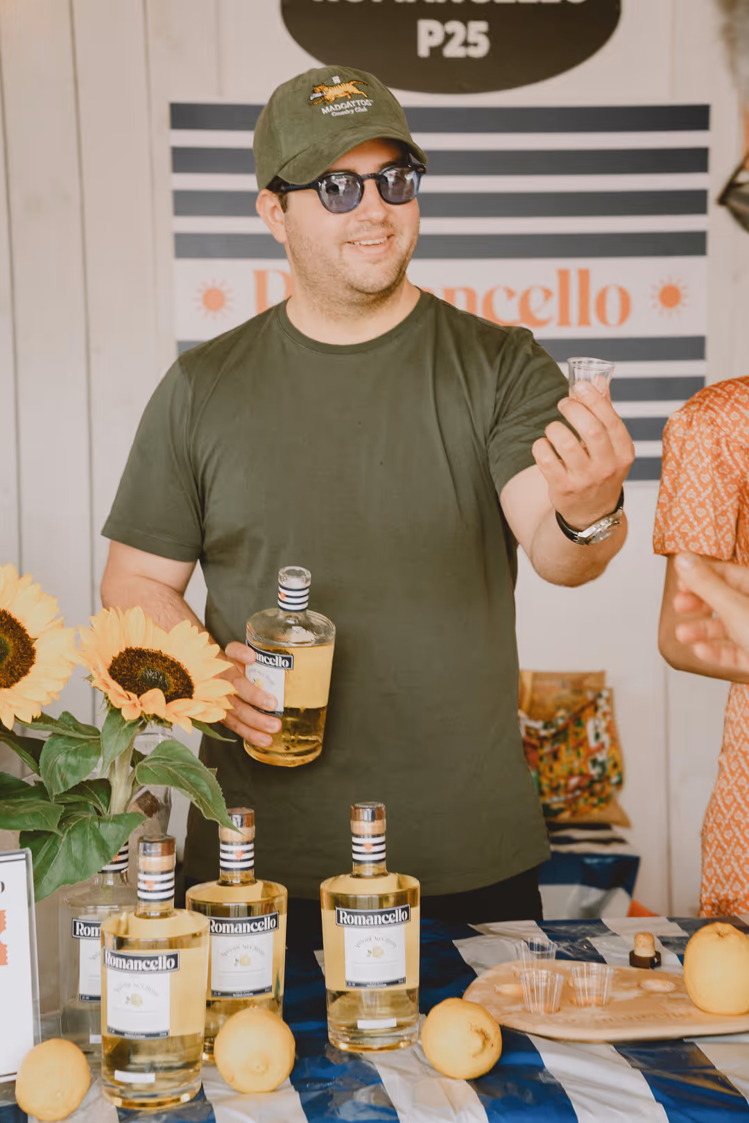 Roman at the Romancello stand, holding a bottle and tasting glass