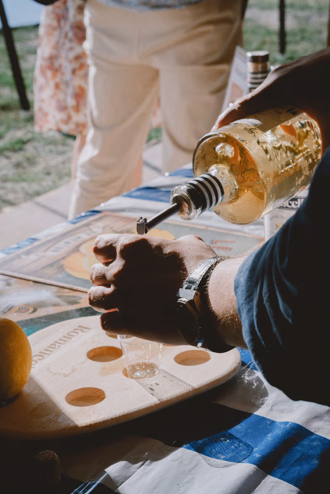 Pouring Romancello neat into tasting glasses at the stand