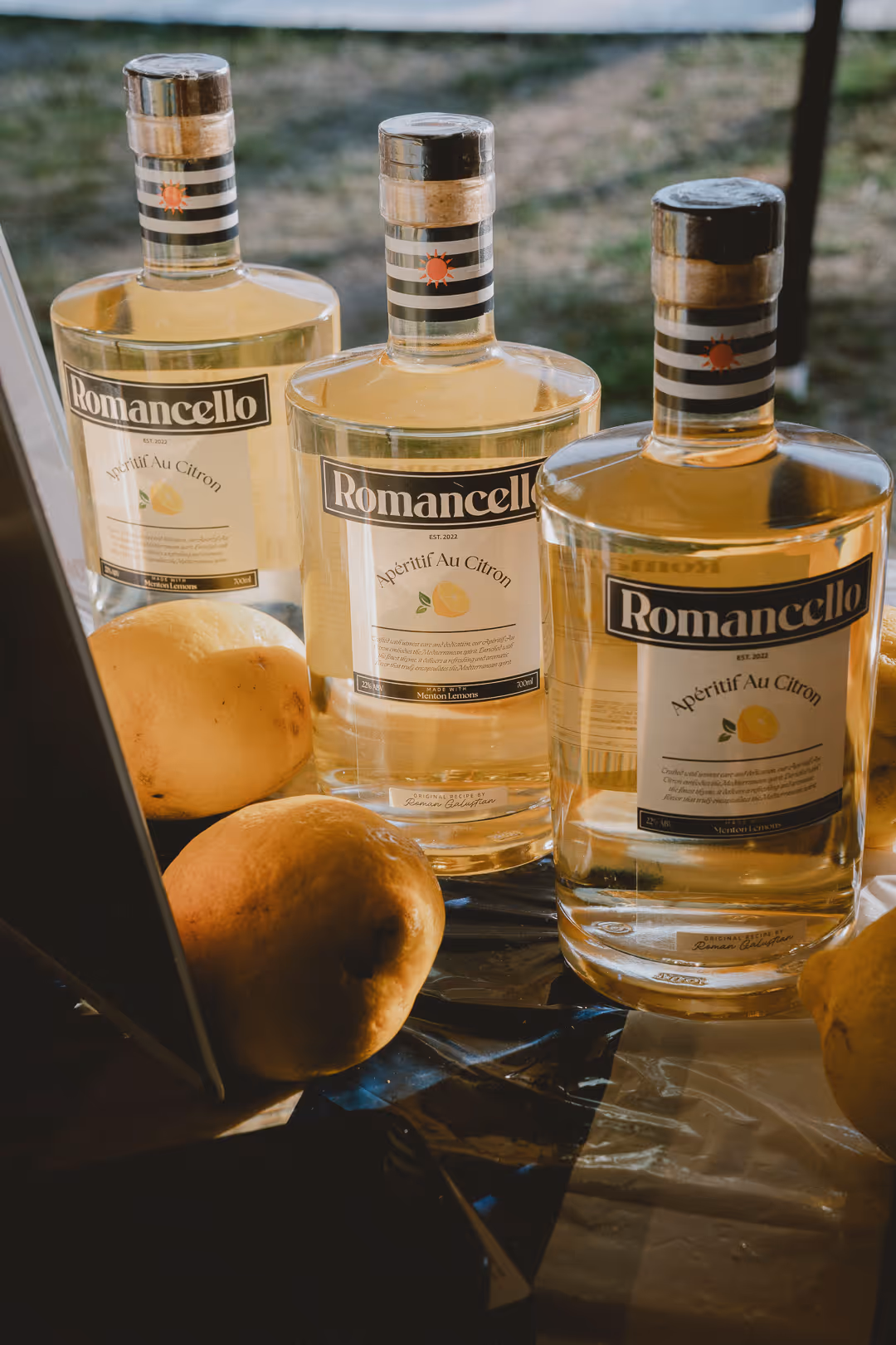 Three Romancello Apéritif Au Citron bottles with Menton lemons