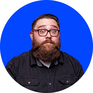 Bearded man with glasses wearing a dark shirt, posing against a solid blue circular background.