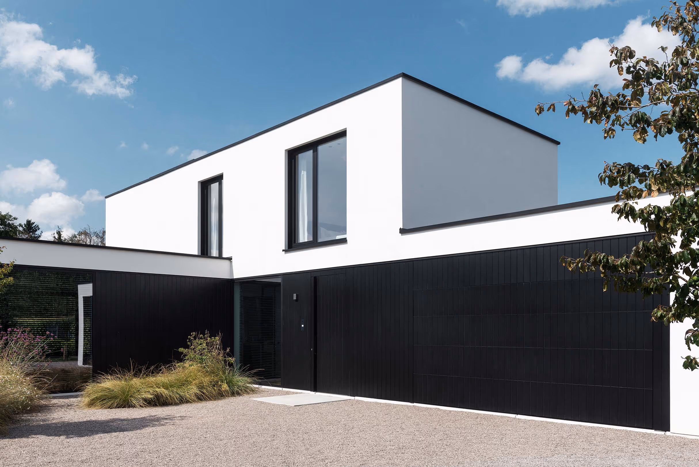 Modern white house with black paneling and large windows