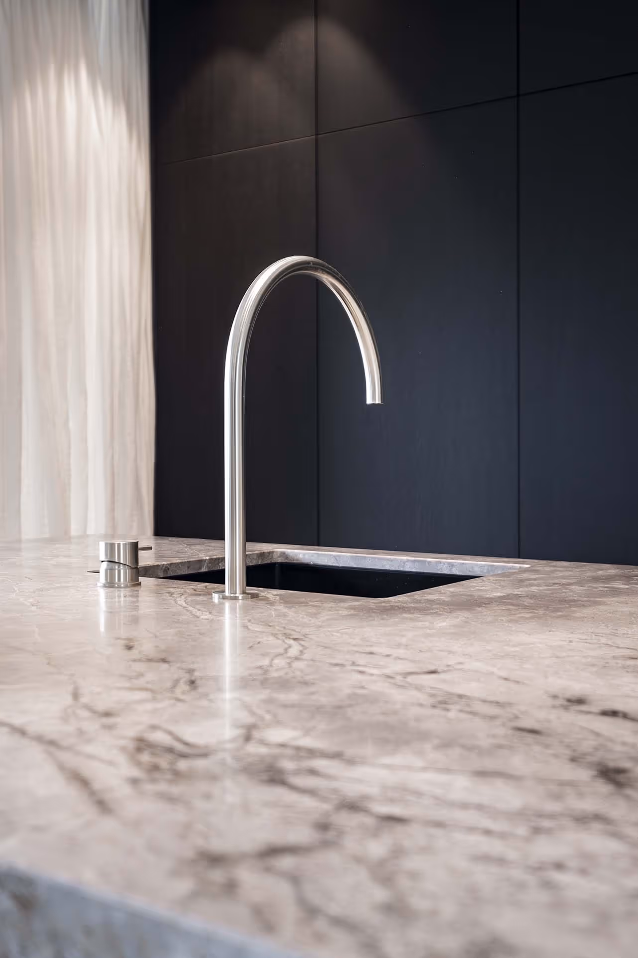 Elegante keukenkraan op marmeren werkblad met zwarte achterwand