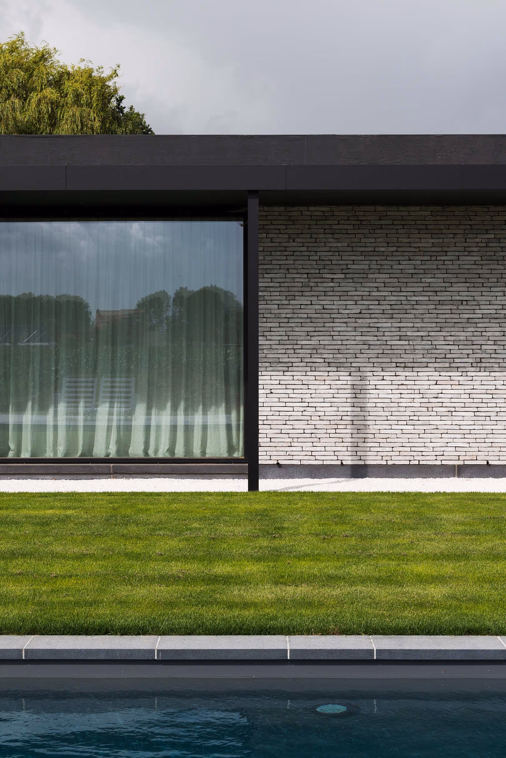 Modern huis met reflecterend zwembad en uitzicht op weelderige tuin