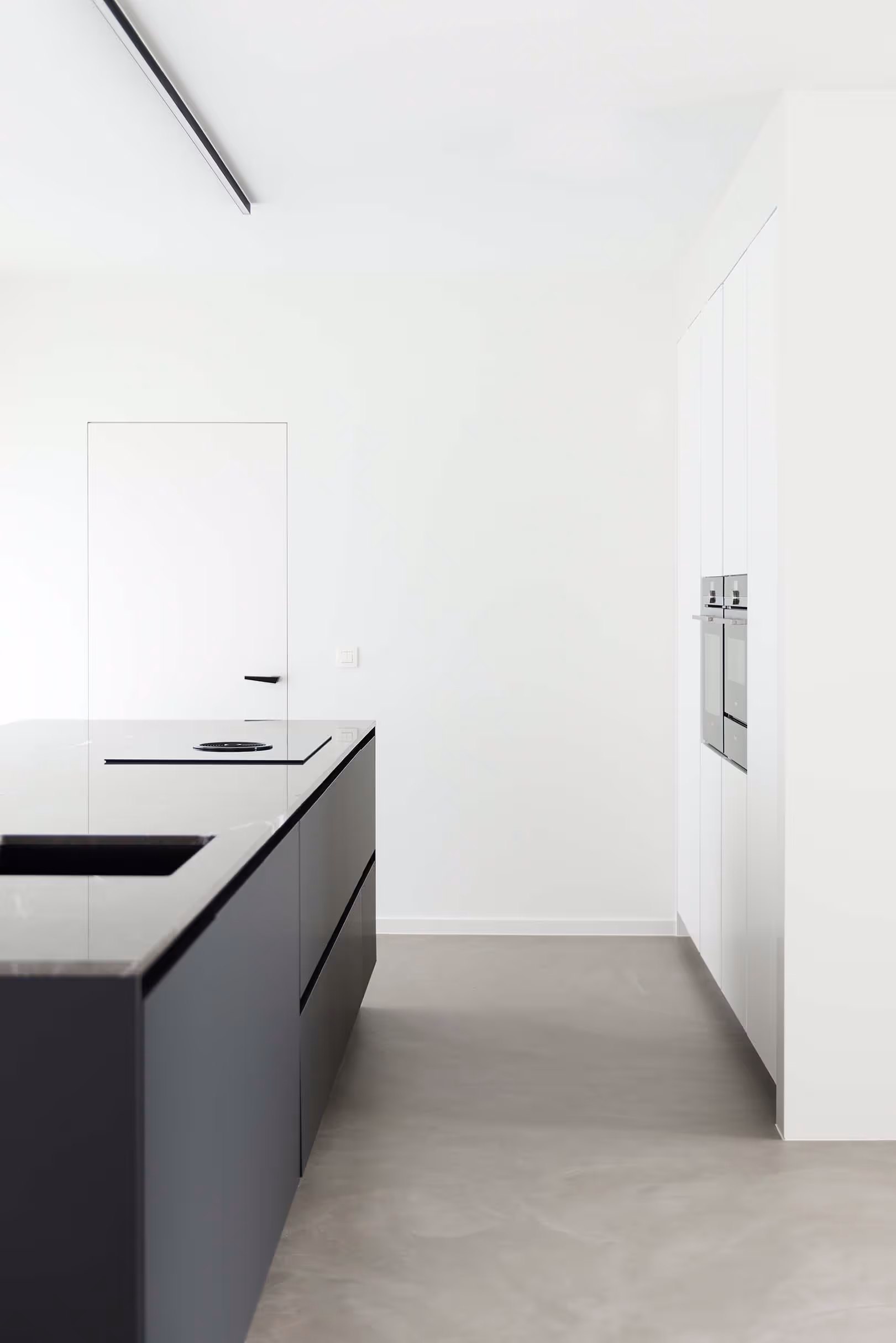 Minimalistische keuken met zwarte kasten en geïntegreerde apparaten