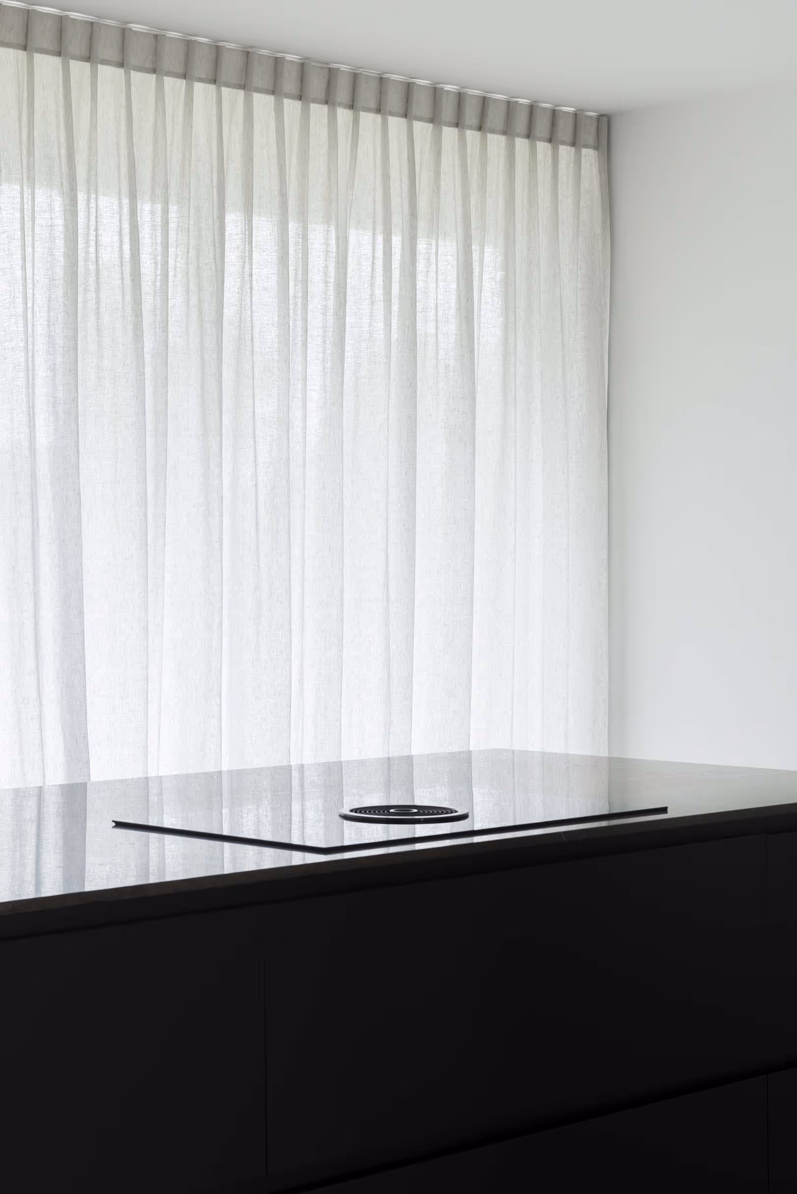 Moderne keuken met grote ramen bedekt door witte doorzichtige gordijnen