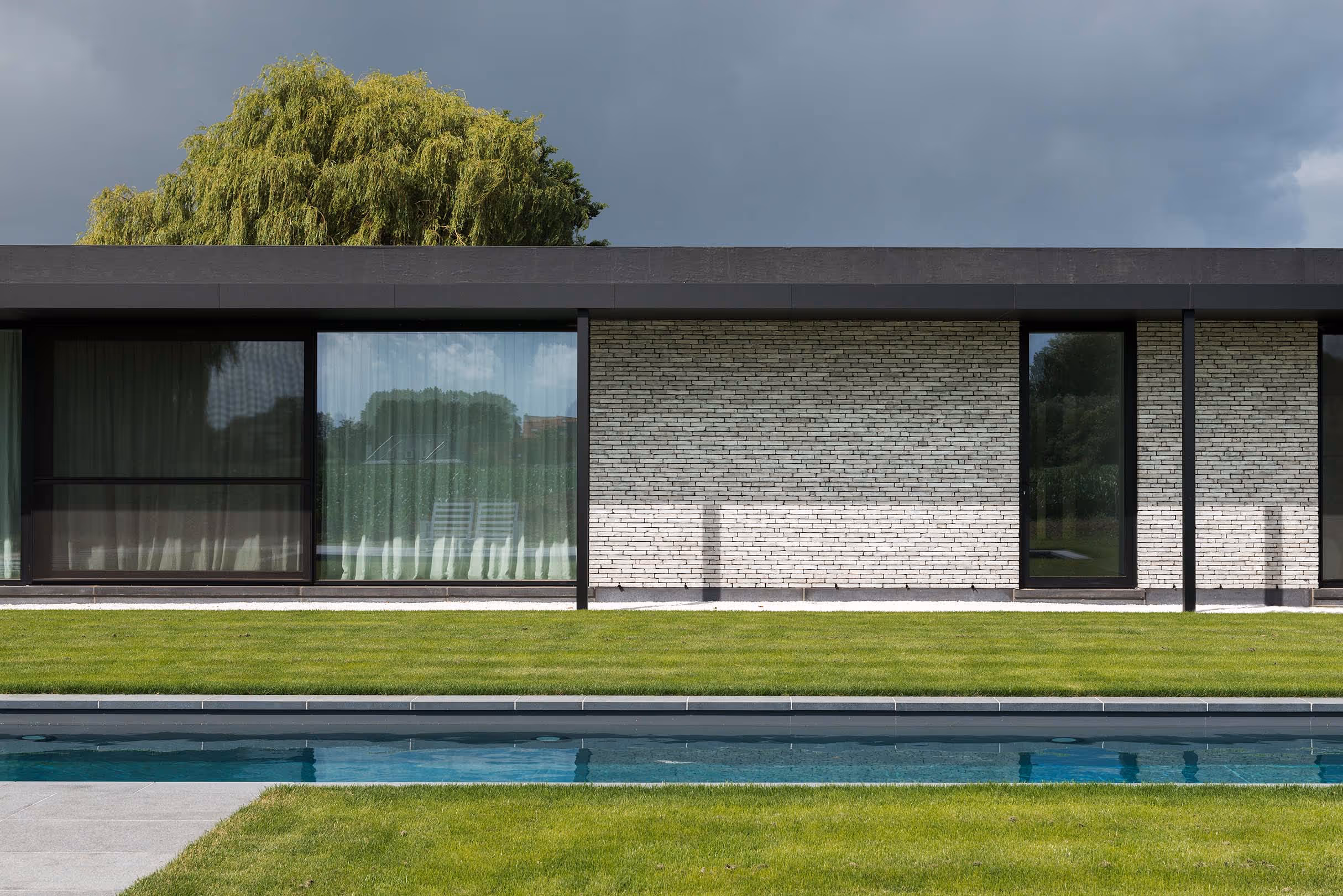 Moderne architectuur met weerspiegeling van een wilg in raam