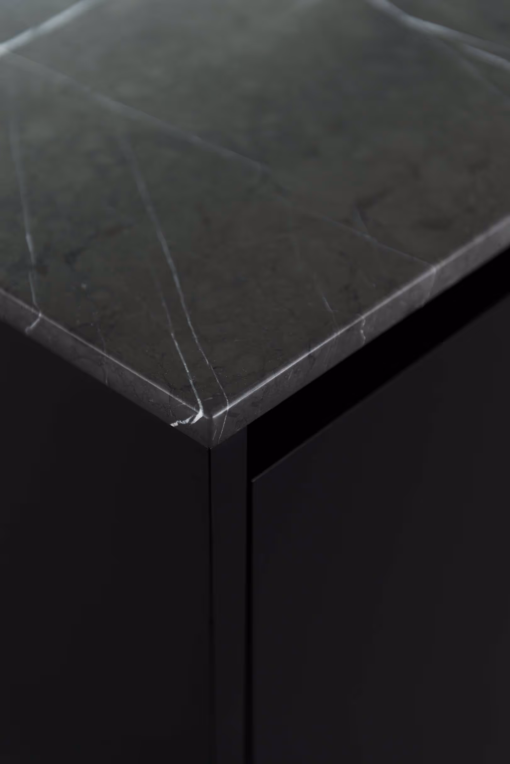 Detail van donker keukeneiland met marmeren werkblad in close-up