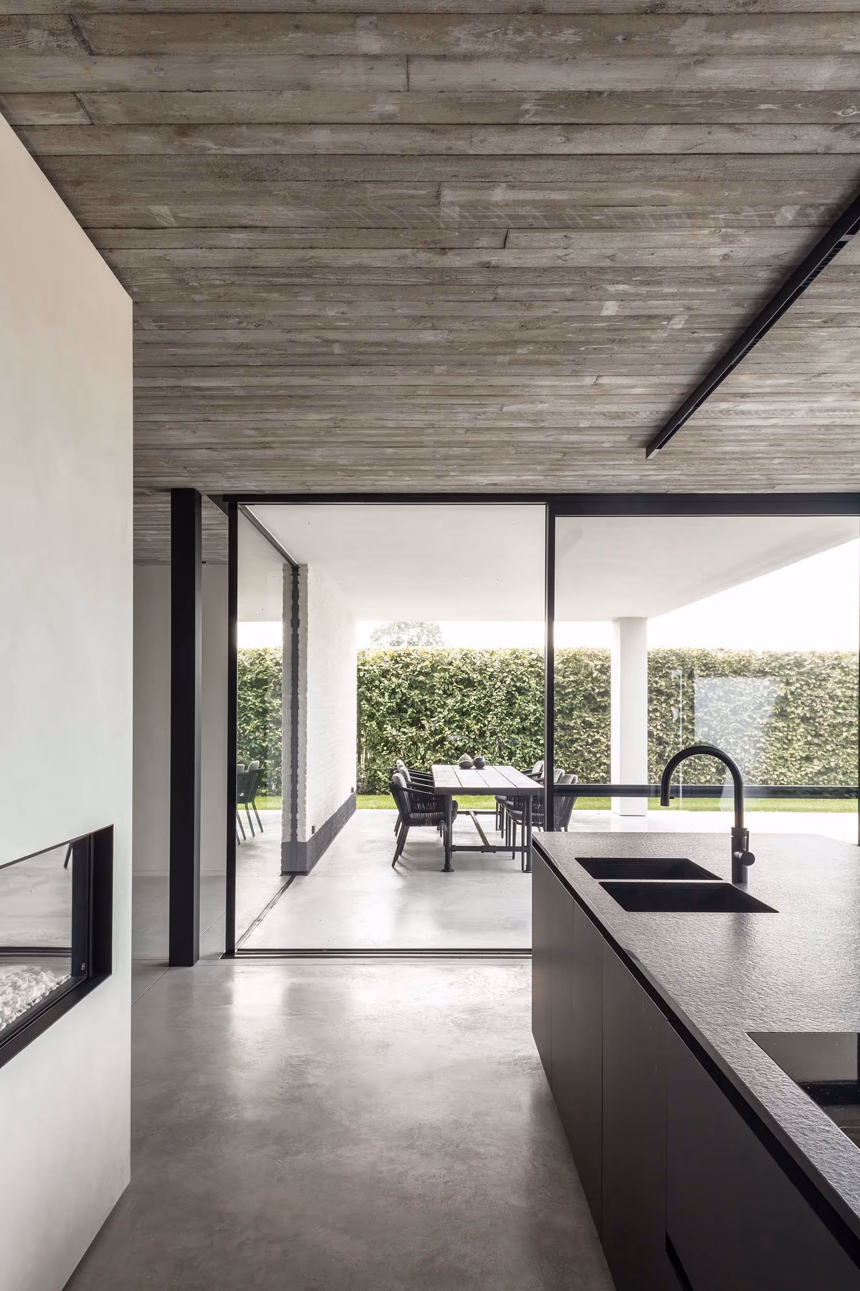 Open keuken en eethoek met directe toegang tot een overdekt terras en buiten eetruimte.