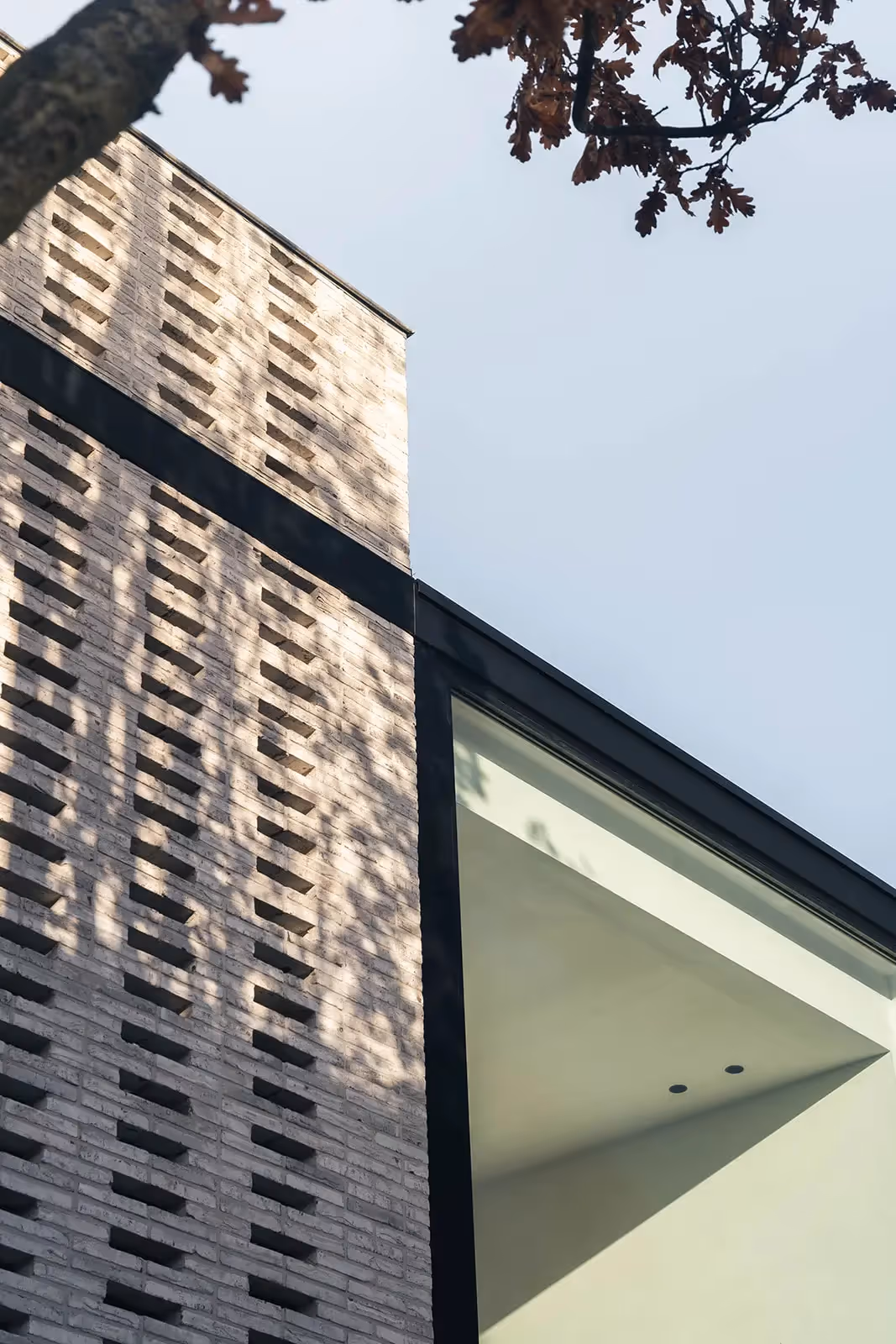 Detail van moderne architectuur met bakstenen textuur en scherpe hoeken.