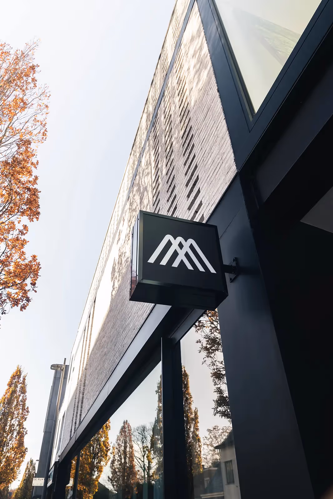 Gevel van modern gebouw met bakstenen en opvallende zwarte omlijsting.