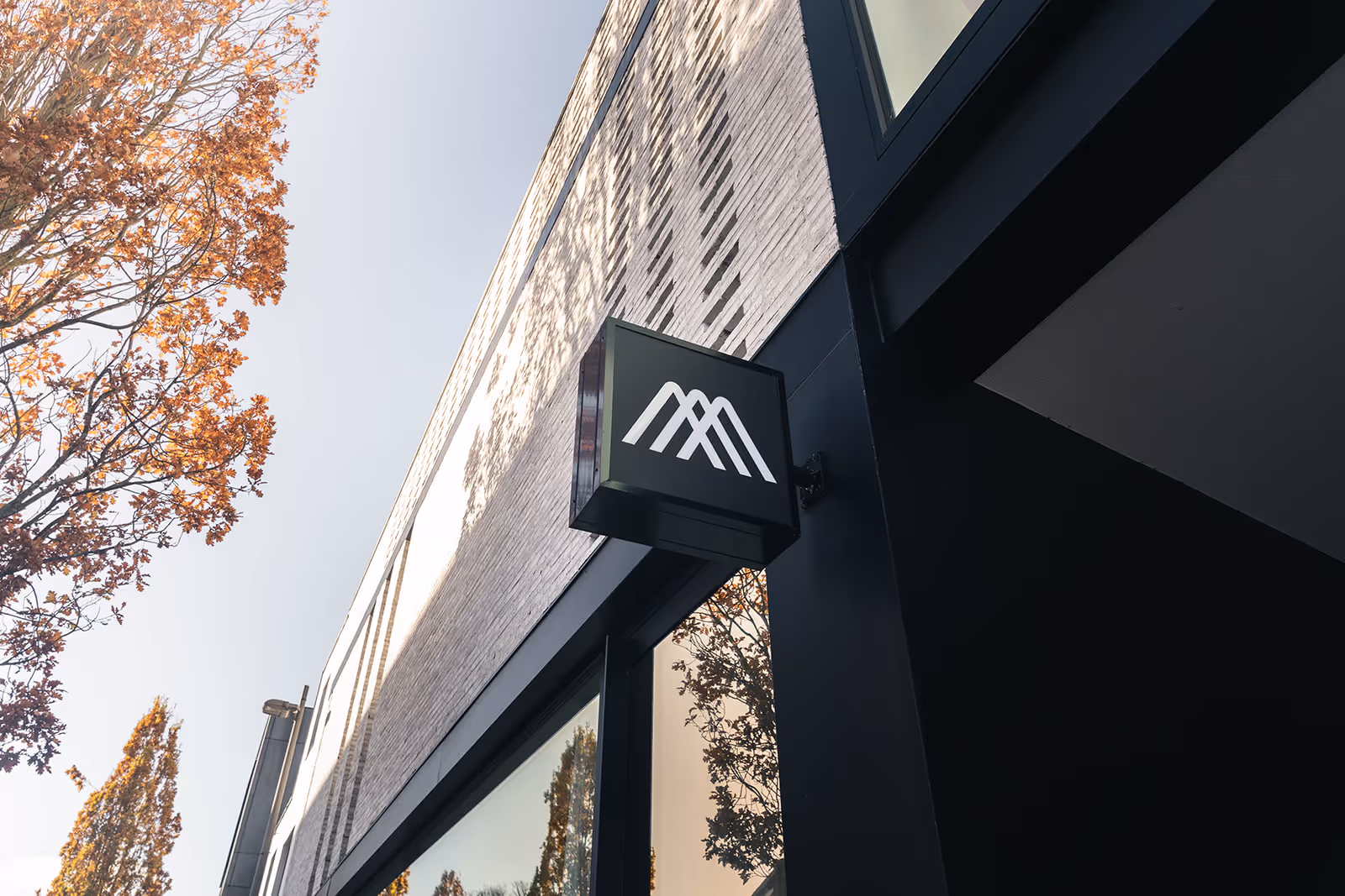 Close-up van een modern gebouw met een baksteenmotief en een groot glazen element.