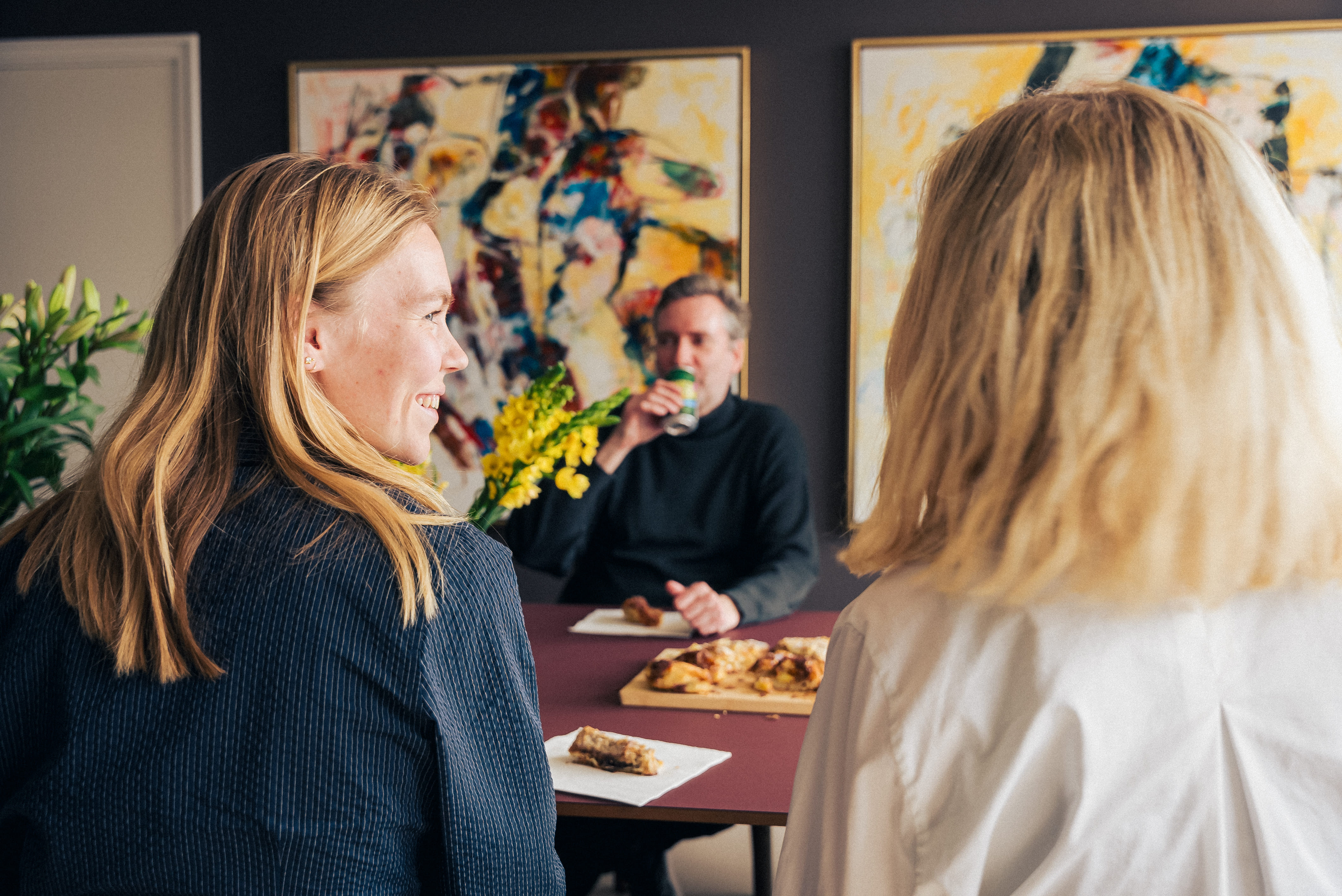 Mindkey-medarbejdere i uformel samtale på kontoret – inkluderende arbejdskultur hos Mindkey HR-software.