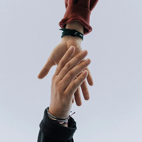 a close up of two people holding hands